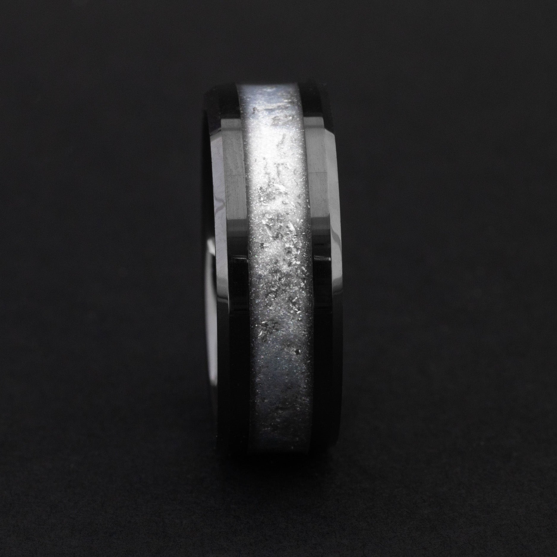 Close up of Gibeon meteorite shavings in a light gray 8mm beveled ceramic ring.