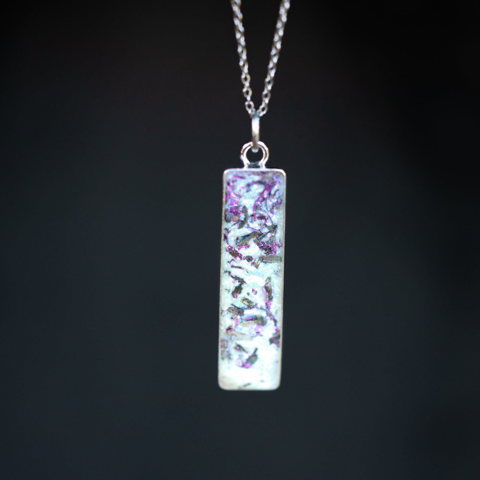 Close-up of the Pink Pearl Bar iridescent bar necklace showing Campo Del Cielo iron meteorite fragments set in pearl-toned white resin with a soft pink shimmer