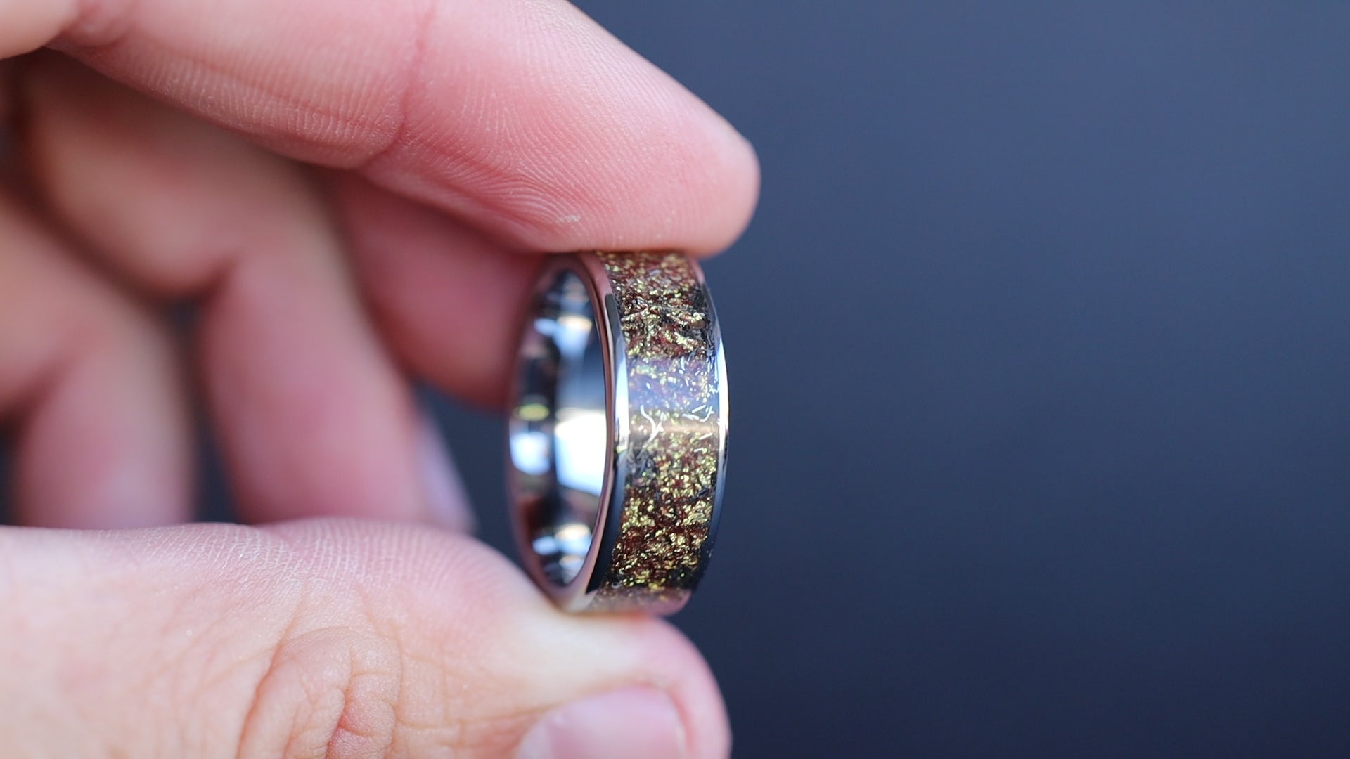 360 degree product view of the Gilded Cosmos Tungsten ring showing Campo del Cielo meteorite shavings shifting through warm gold galaxy pigment inlay on 8mm wide channel tungsten band