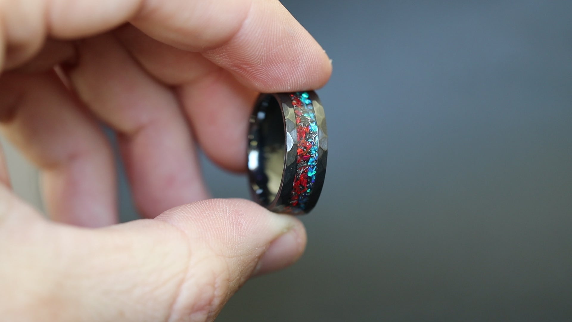 Cinematic view of the Fire and Ice Hammered ring showing the meteorite sparkle and shifting red-blue colors.