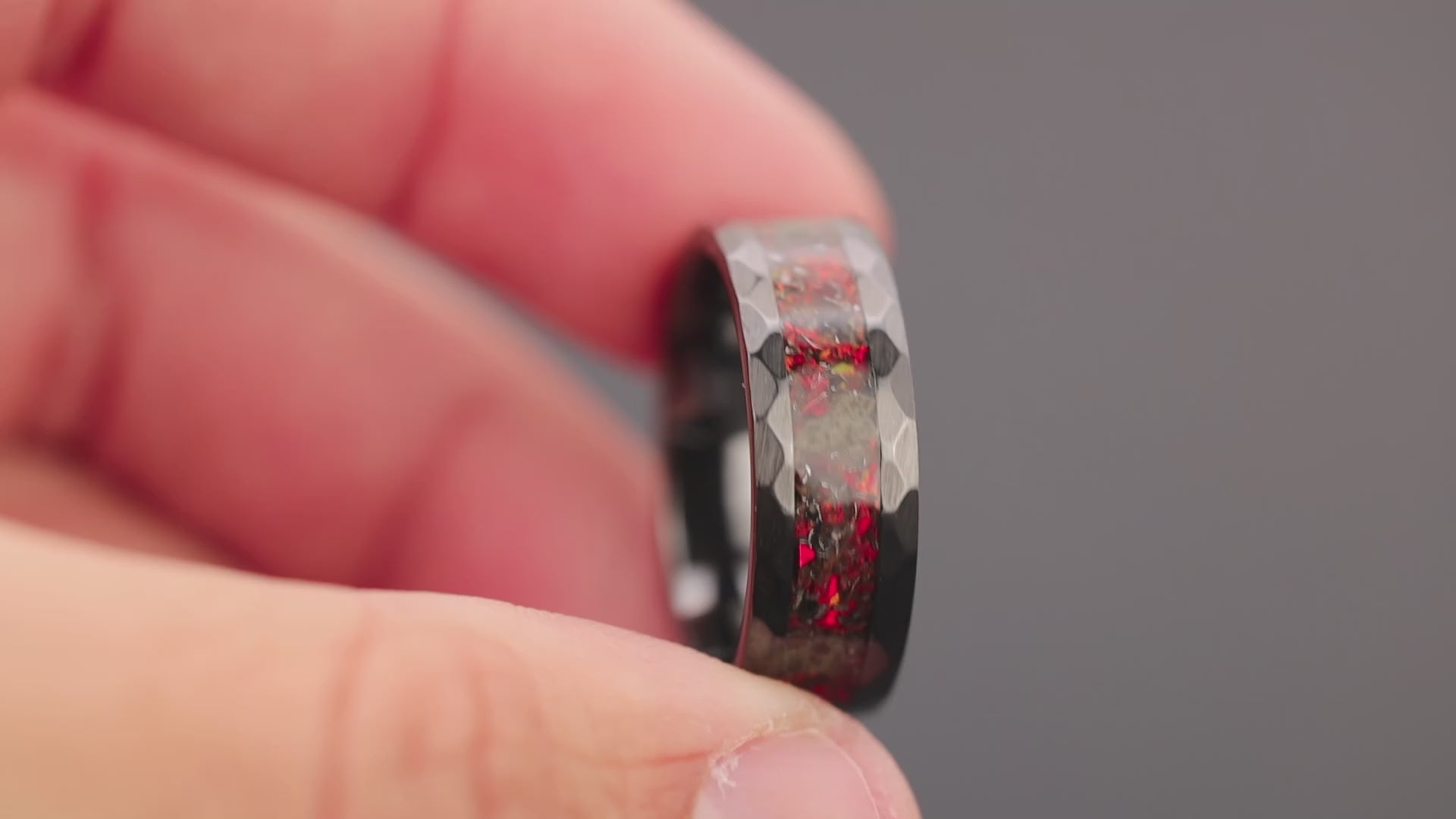 360 degree product view of the Martian Trex Red ring showing T-Rex bone and Martian meteorite shifting through red opal inlay on hammered black ceramic band