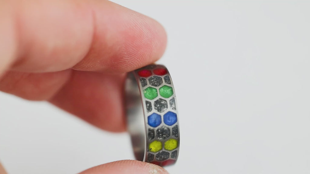 360 degree product view of the Cosmic Infinity ring showing Campo del Cielo meteorite dust and alternating red blue yellow green resin cells in titanium honeycomb band