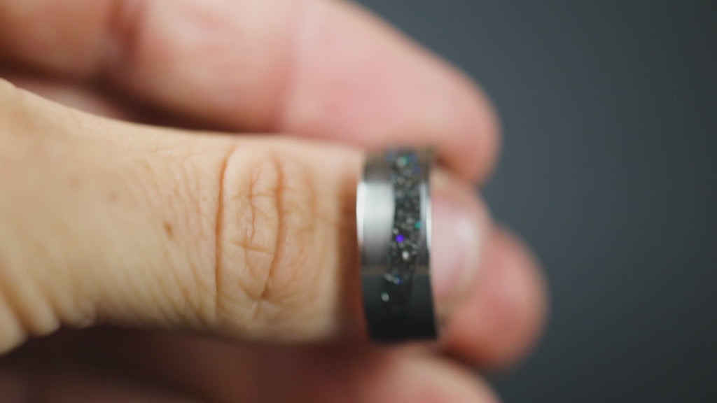 Rotating view of the Blue Cosmic Current titanium ring showing meteorite and blue opal inlay flowing through the curved channel.