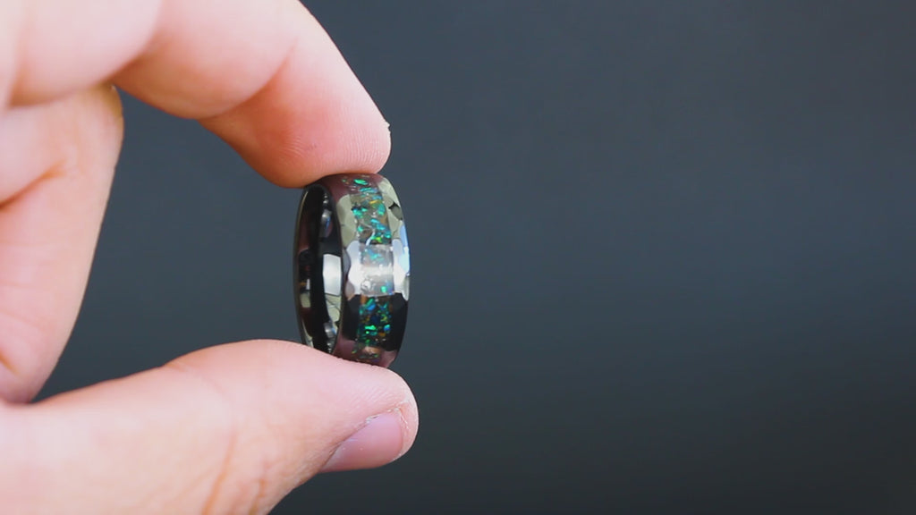 360 degree product view of the Apex Green ring showing T-Rex bone and Campo del Cielo meteorite shifting through green opal inlay on hammered black ceramic band