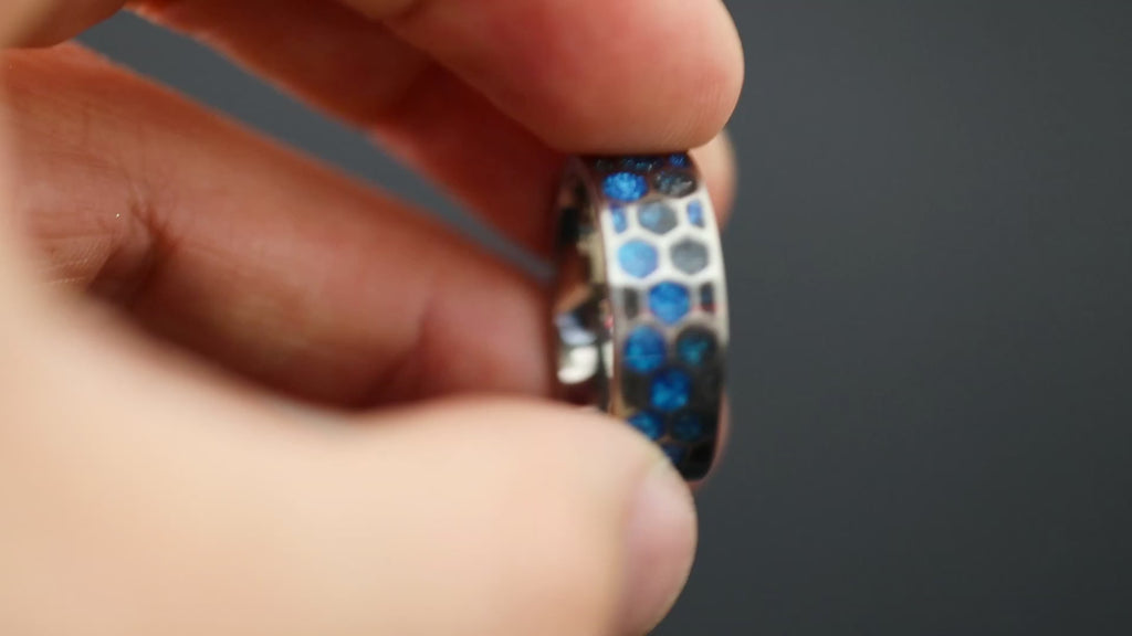 360 degree product view of the Blue Hex Glow ring showing Campo del Cielo meteorite pieces in blue resin honeycomb cells transitioning to blue glow in the dark on 8mm titanium band
