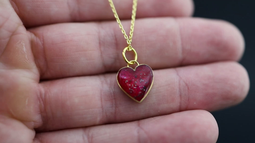Video of the Ruby Pulse handcrafted gold heart pendant necklace in gold-plated sterling silver featuring Campo Del Cielo meteorite and red resin inlay
