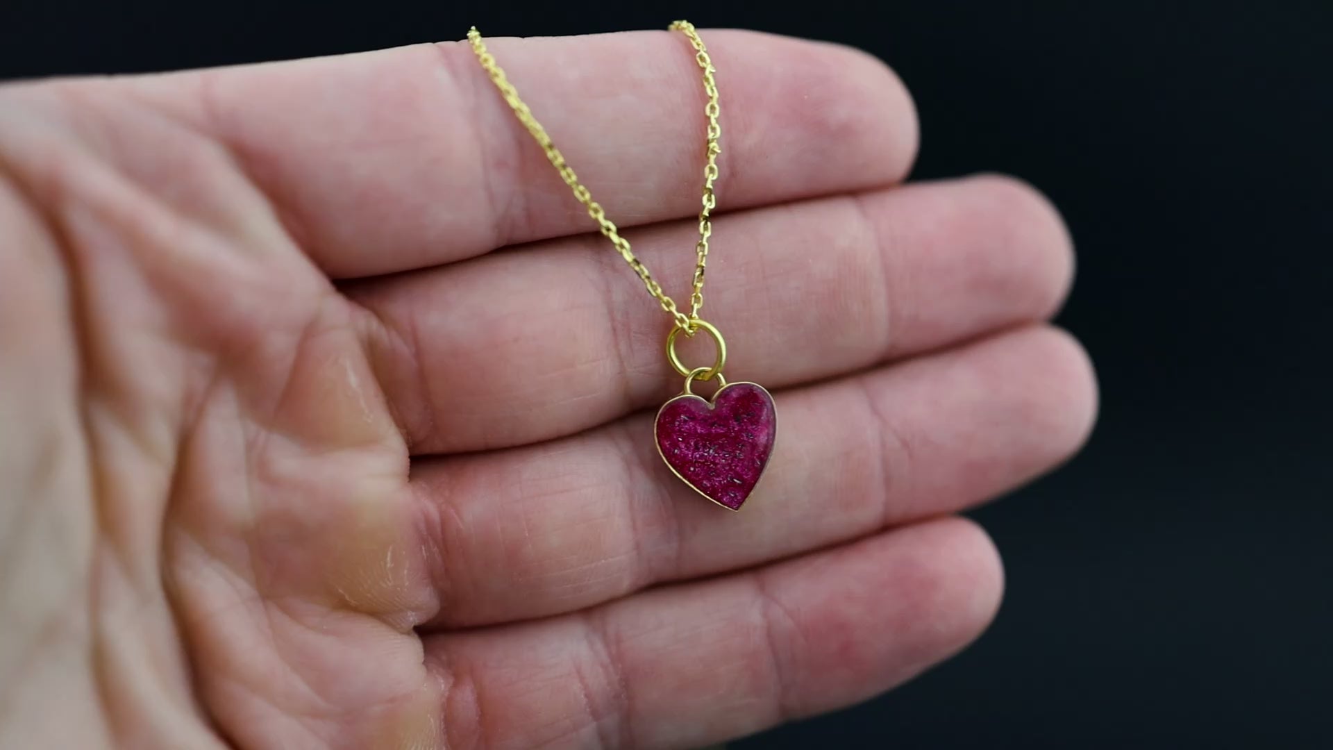 Video of the Pink Pulse handcrafted pink heart necklace in gold-plated sterling silver featuring authentic Campo Del Cielo meteorite and vivid pink resin inlay