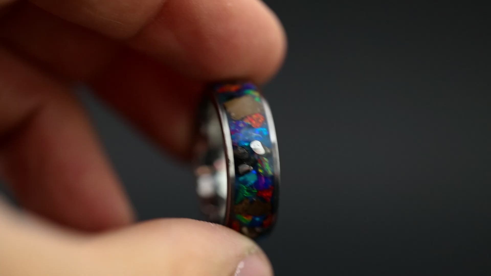 360 degree product view of the Epic Rex Spectrum ring showing large T-Rex bone pieces and Campo del Cielo meteorite chunks shifting through multi-color opal mosaic on 8mm wide channel tungsten band