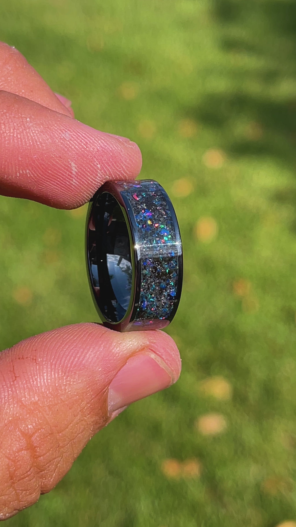360 degree product view of the Midnight Megalodon Ceramic ring showing Megalodon tooth and Campo del Cielo meteorite shifting through midnight opal inlay transitioning to blue glow in the dark on wide channel ceramic band