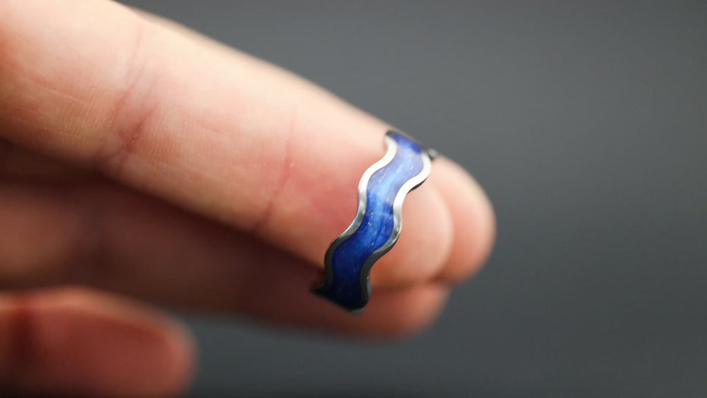 360 degree product view of the Blue Orbit Wiggle ring showing Campo del Cielo meteorite pieces shifting through blue resin inlay on 8mm titanium wiggle band with wave profile