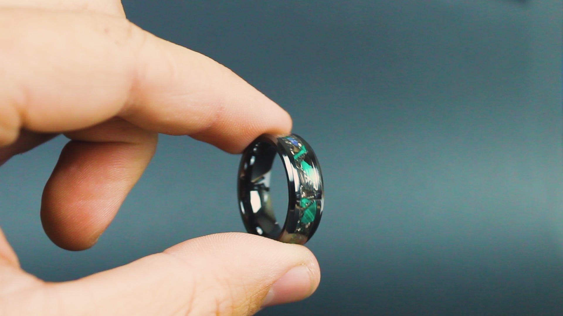 360 degree product view of the Rex Terra ring showing T-Rex bone, Campo del Cielo meteorite, malachite, and Ethiopian Opal shifting on 8mm beveled black ceramic band