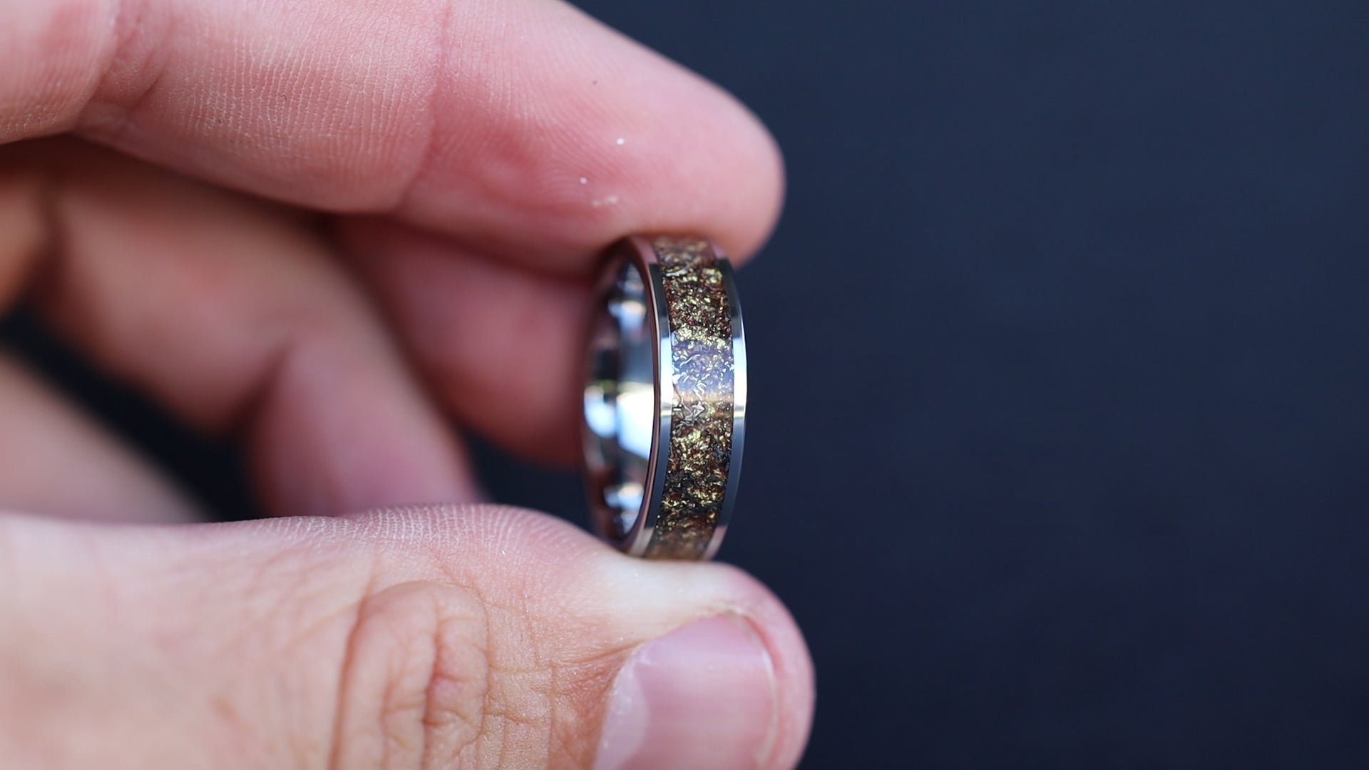 360 degree product view of the Gilded Cosmos ring showing Campo del Cielo meteorite shavings shifting through warm gold galaxy pigment inlay on wide channel tungsten band