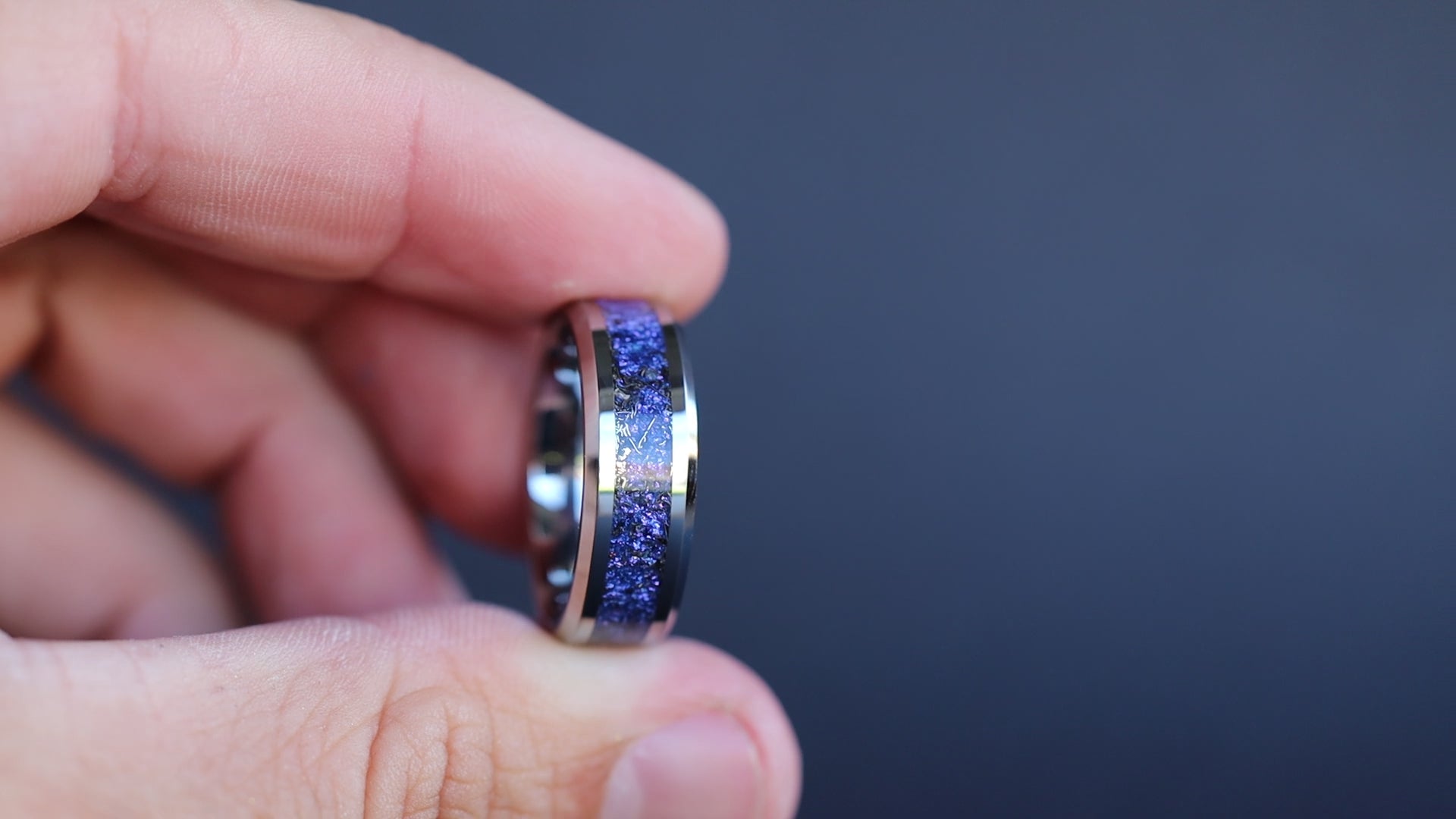 360 degree product view of the Cosmic Midnight Tungsten ring showing Campo del Cielo meteorite shavings shifting through deep purple and blue midnight galaxy pigment inlay on 8mm beveled tungsten band