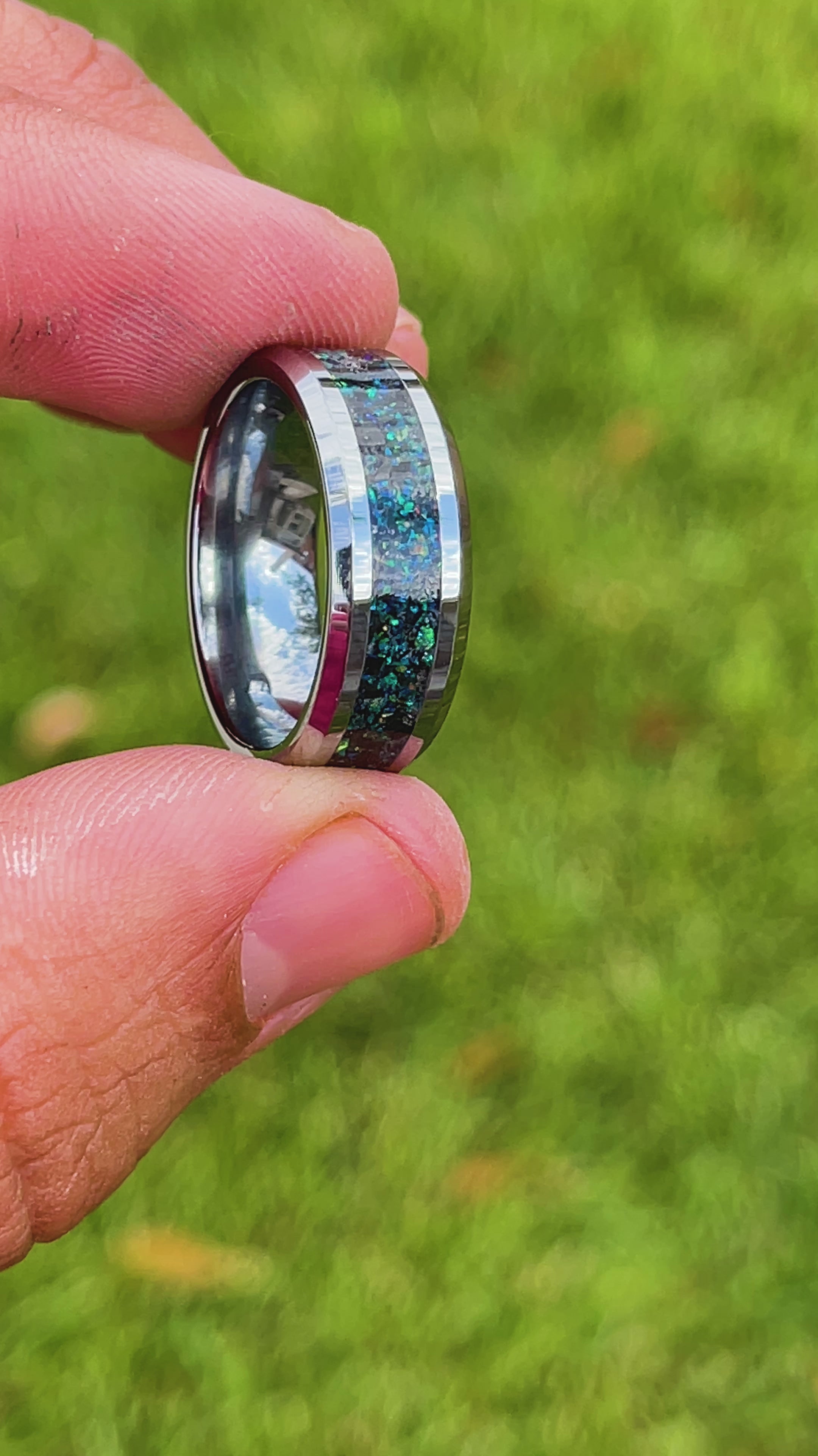 360 degree product view of the Deep Sea Megalodon ring showing Megalodon tooth and Campo del Cielo meteorite shifting through blue and green opal iridescent inlay on 8mm beveled tungsten band