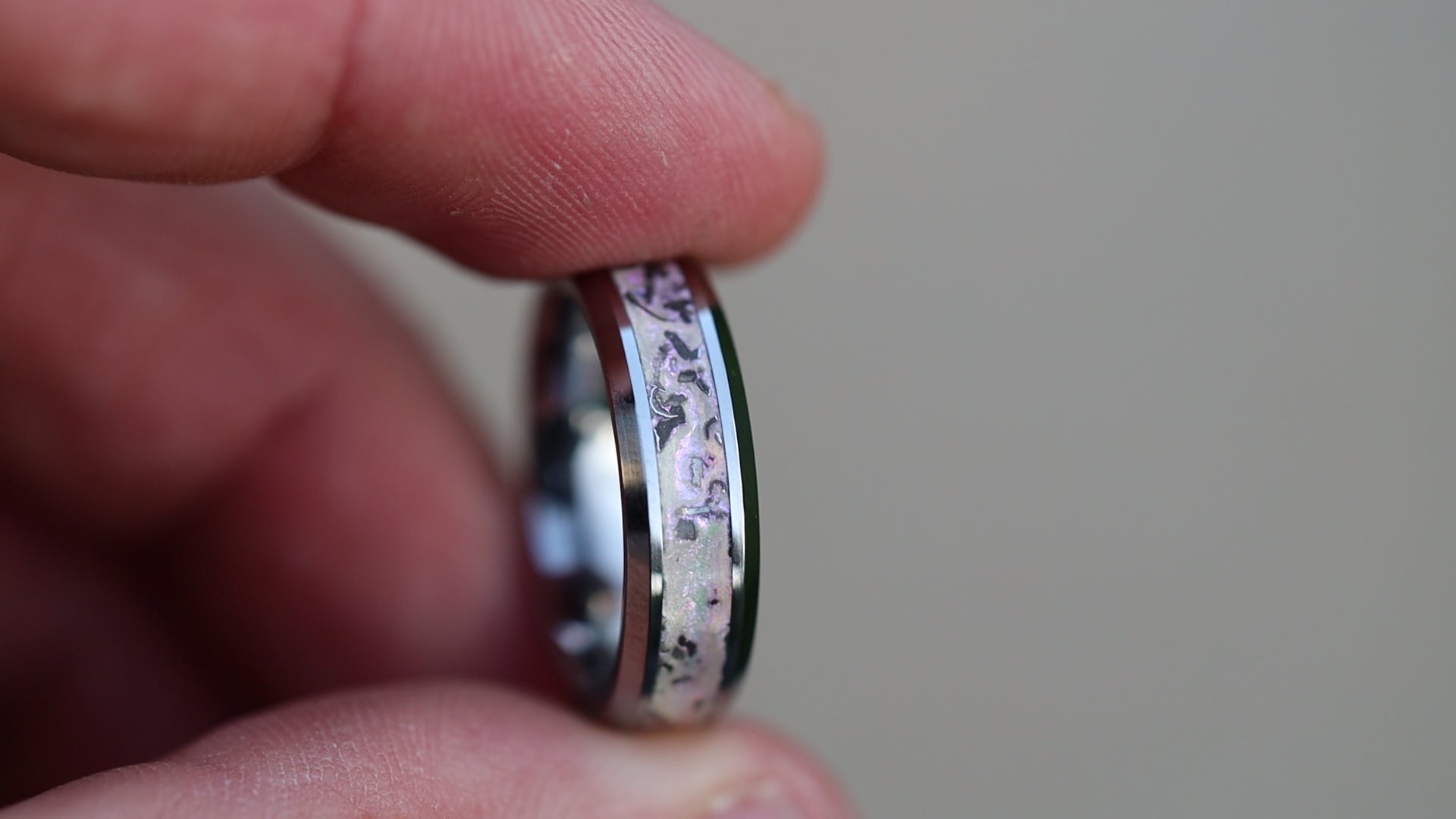 360 degree product view of the White Pearl Meteorite ring showing Campo del Cielo meteorite shavings shifting through white pearl glitter inlay on beveled tungsten band