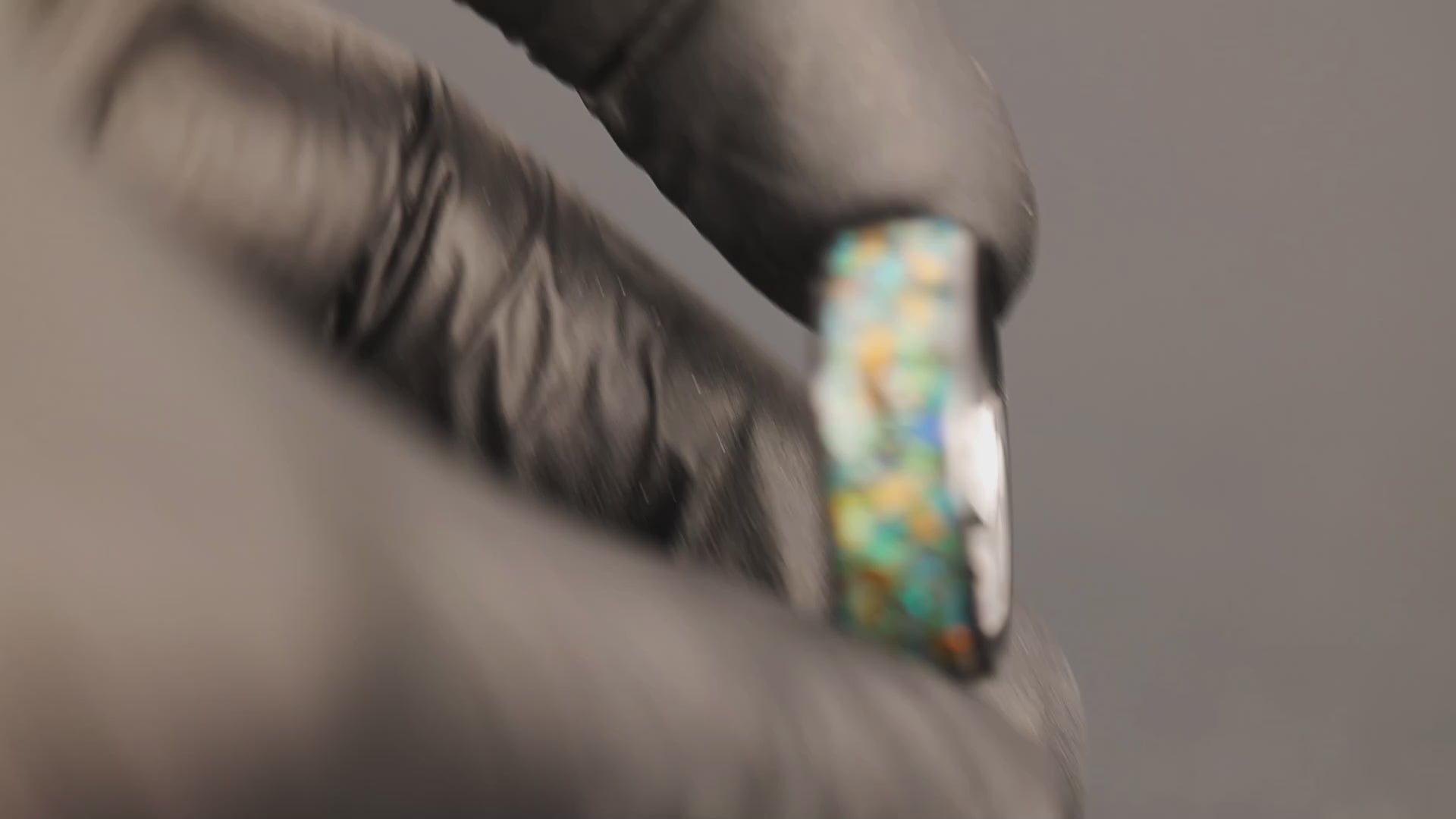 Video of the Cosmic Predator Ring handcrafted 8mm wide channel black ceramic mens wedding band featuring authentic Campo Del Cielo meteorite, real T-Rex bone, real velociraptor bone, and galaxy opal and glitter inlay