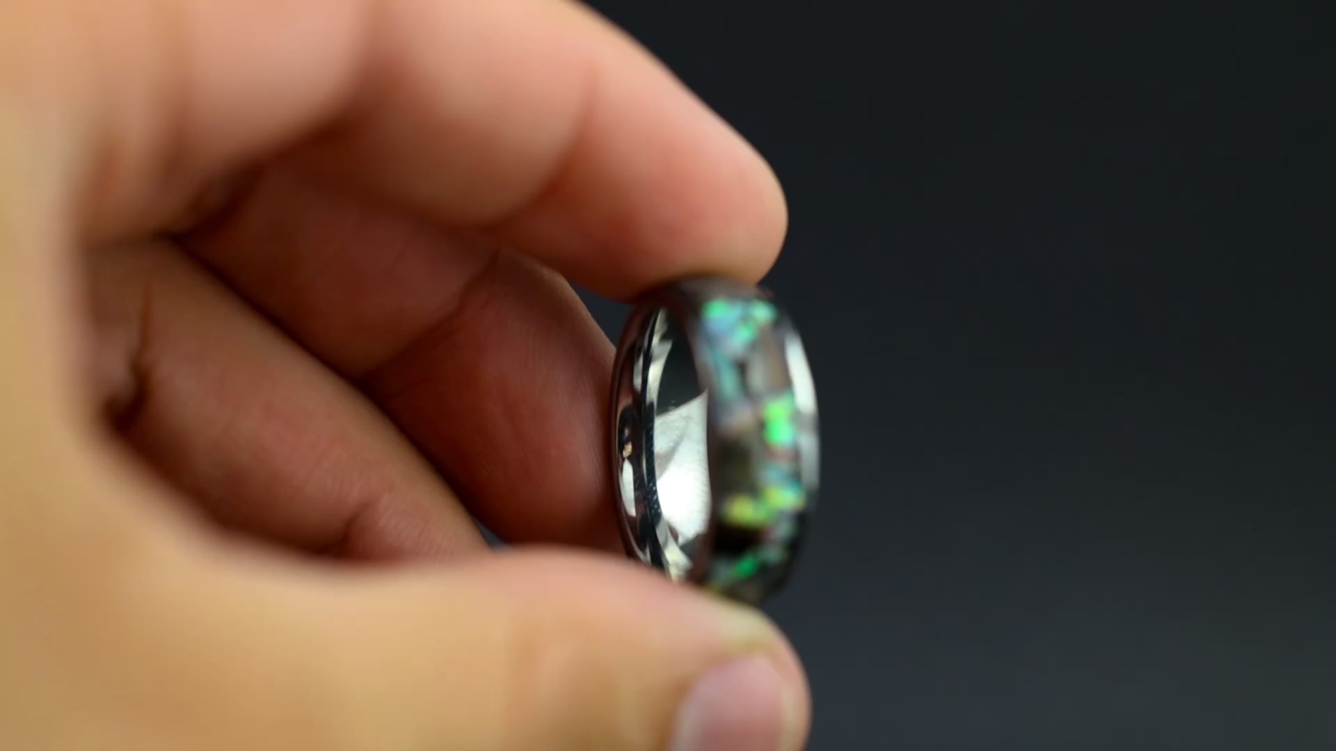 360 degree product view of the Lunar Rex Pearl ring showing large T-Rex bone pieces and lunar meteorite chunks shifting through white pearl opal inlay on 8mm wide channel tungsten band