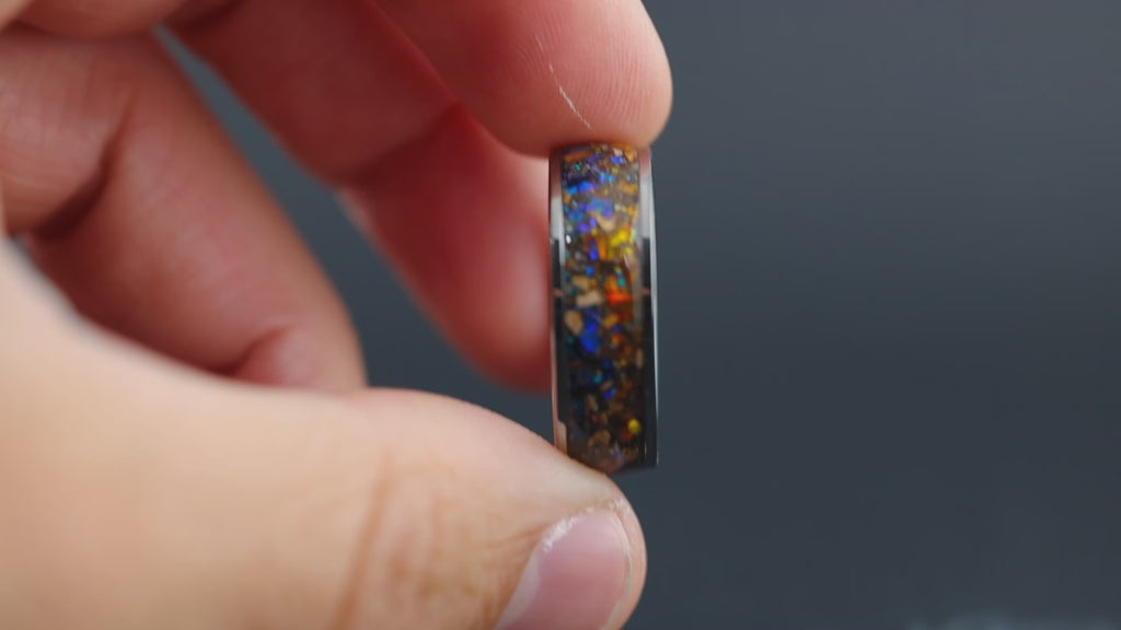 Dynamic view of the Thermal Velocity ring showing the light-catching blue and orange opals and metallic meteorite grain.