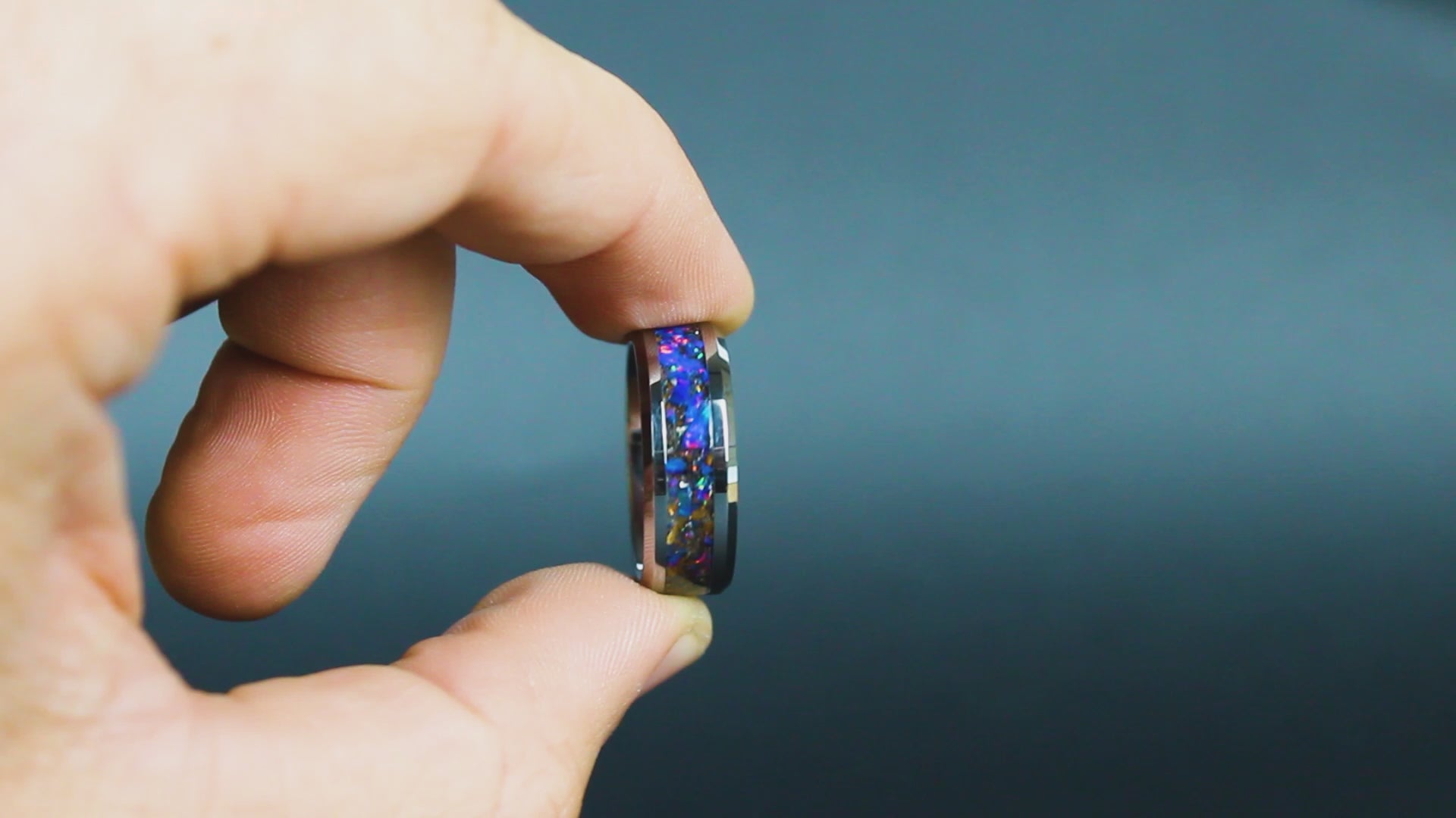 360 degree product view of the Velociraptor Midnight ring showing Velociraptor bone and Campo del Cielo meteorite shifting through midnight blue purple opal inlay on beveled tungsten band