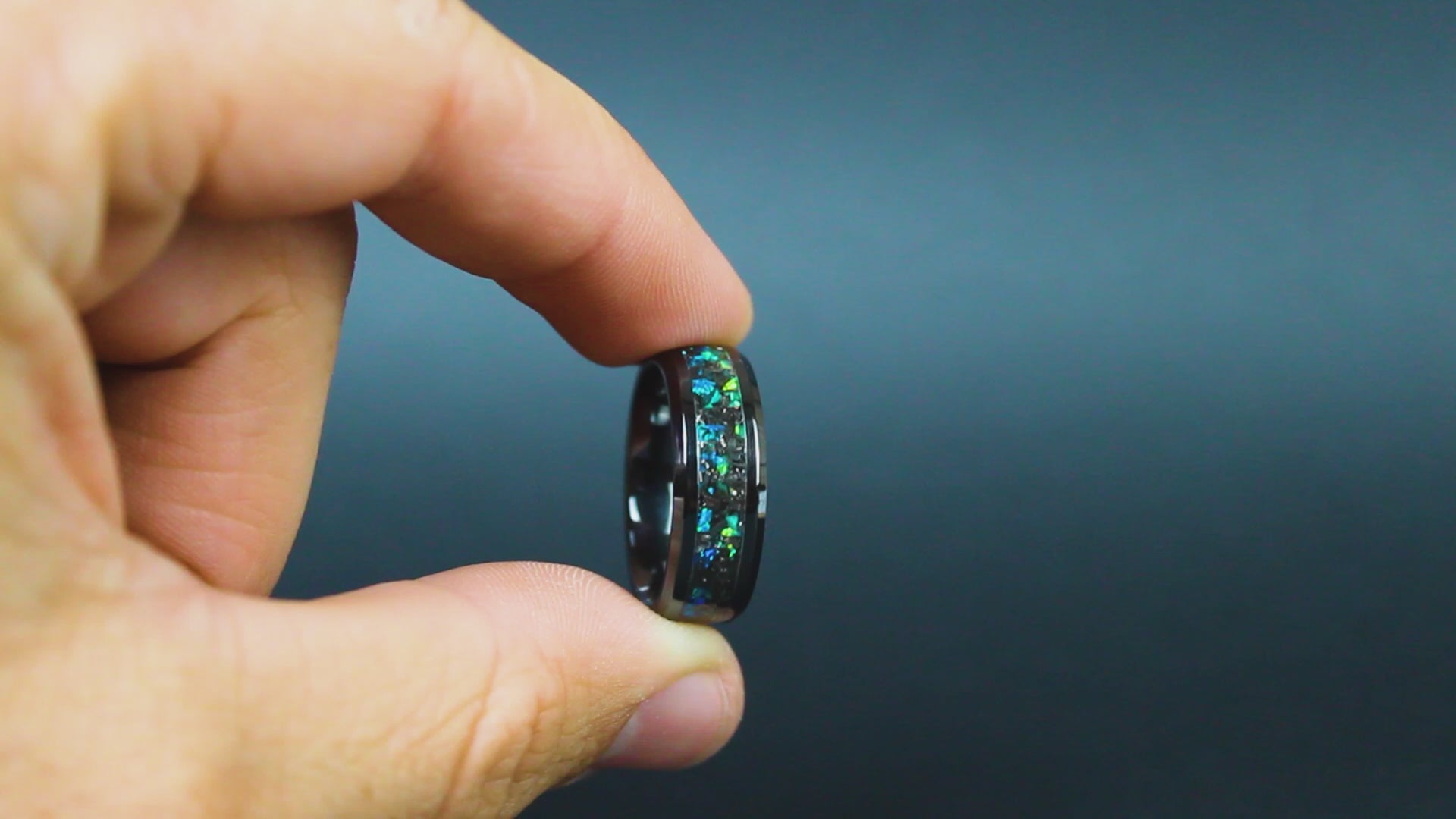360 degree product view of the Divided Seas ring showing Campo del Cielo meteorite shavings shifting through split blue and green opal inlay on 8mm beveled black ceramic band