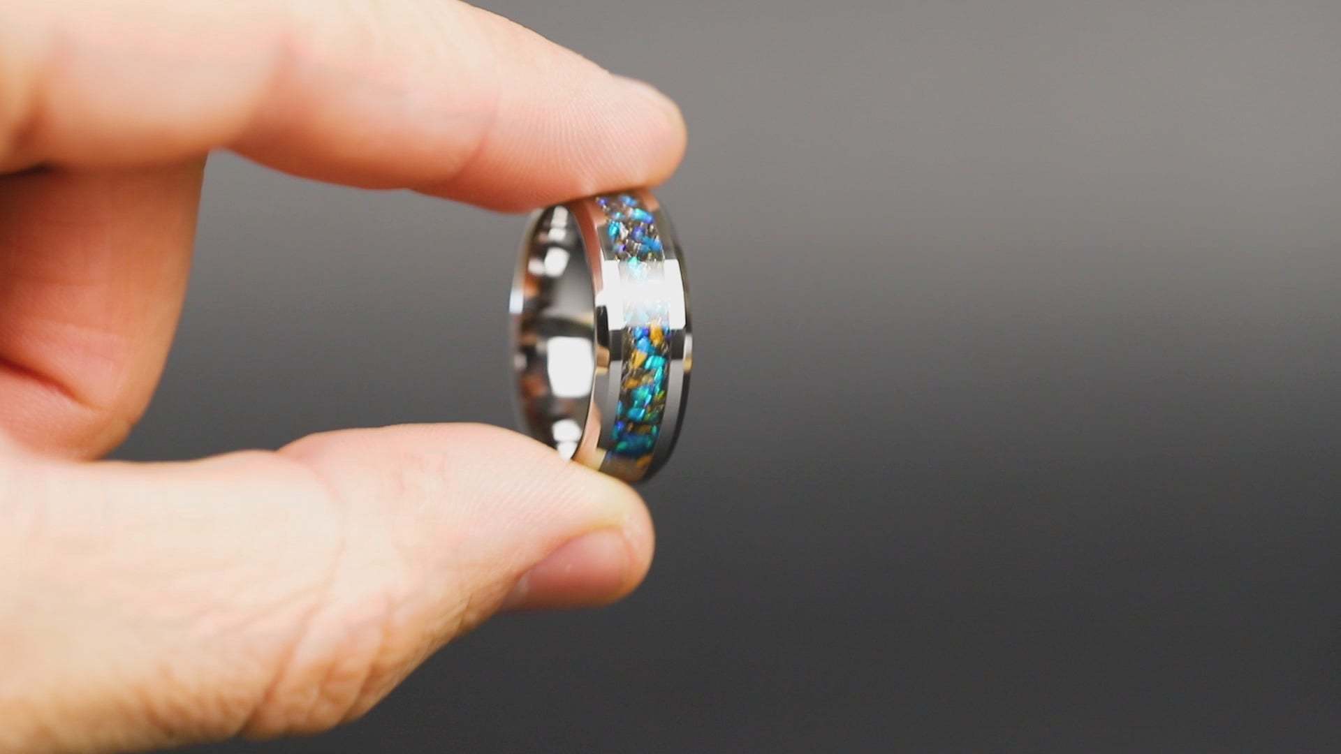 360 degree product view of the Cobalt Velociraptor ring showing Velociraptor bone and Campo del Cielo meteorite shifting through blue opal inlay on 8mm beveled tungsten band