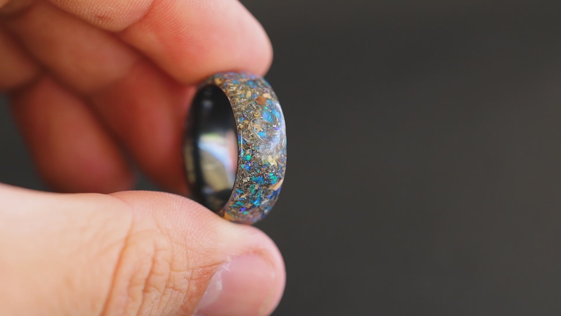360 degree product view of the Endless Deep Origin ring showing Mosasaur bone, Dinosaur Gembone, and Campo del Cielo meteorite shifting through blue opal inlay on endless ceramic band