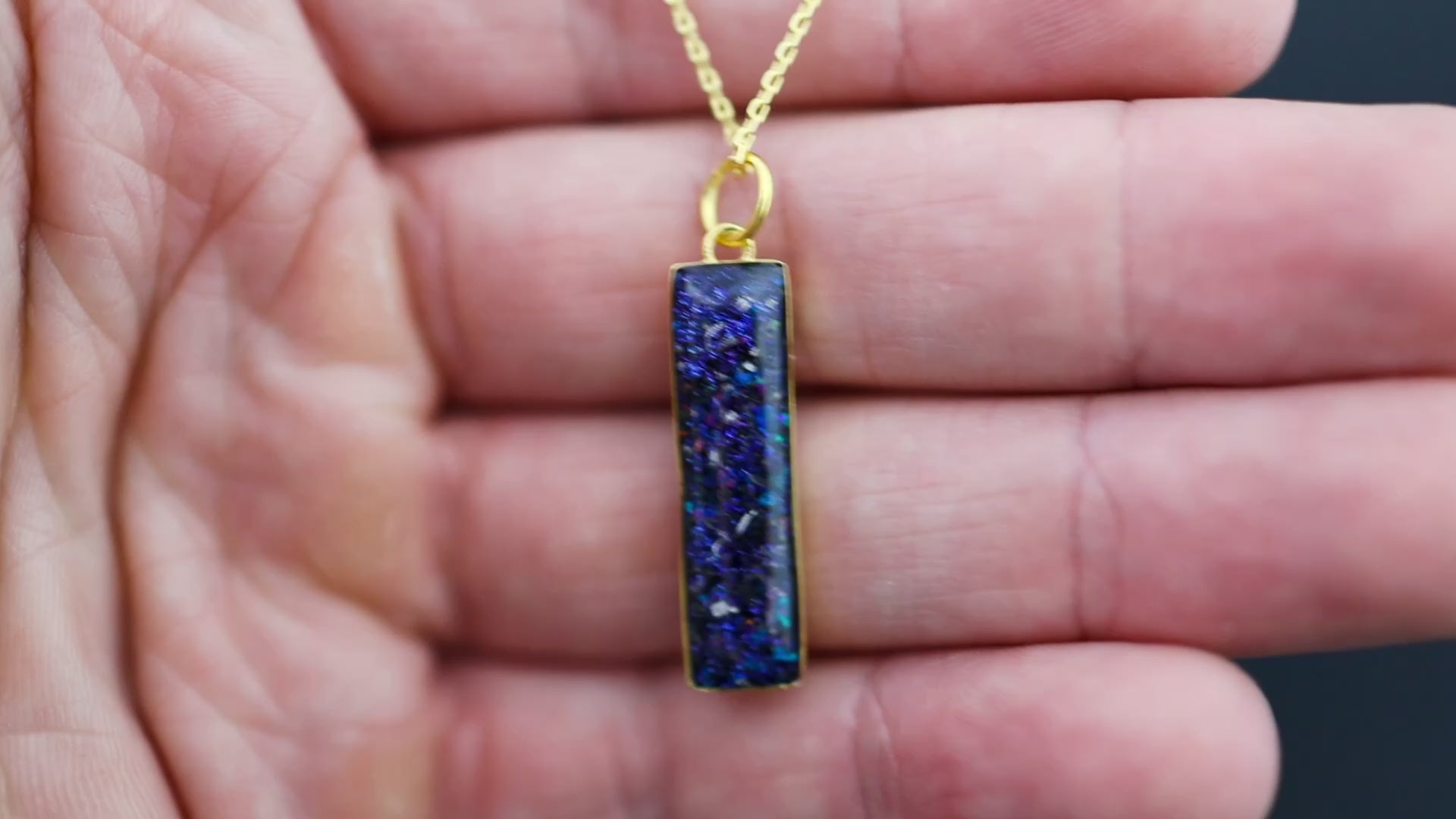 Video of the Galaxy Bar Gold pendant necklace in gold-plated sterling silver featuring Campo Del Cielo meteorite, blue and purple opals, and pigment glitter inlay