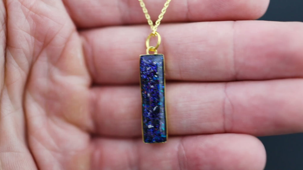 Video of the Galaxy Bar Gold pendant necklace in gold-plated sterling silver featuring Campo Del Cielo meteorite, blue and purple opals, and pigment glitter inlay