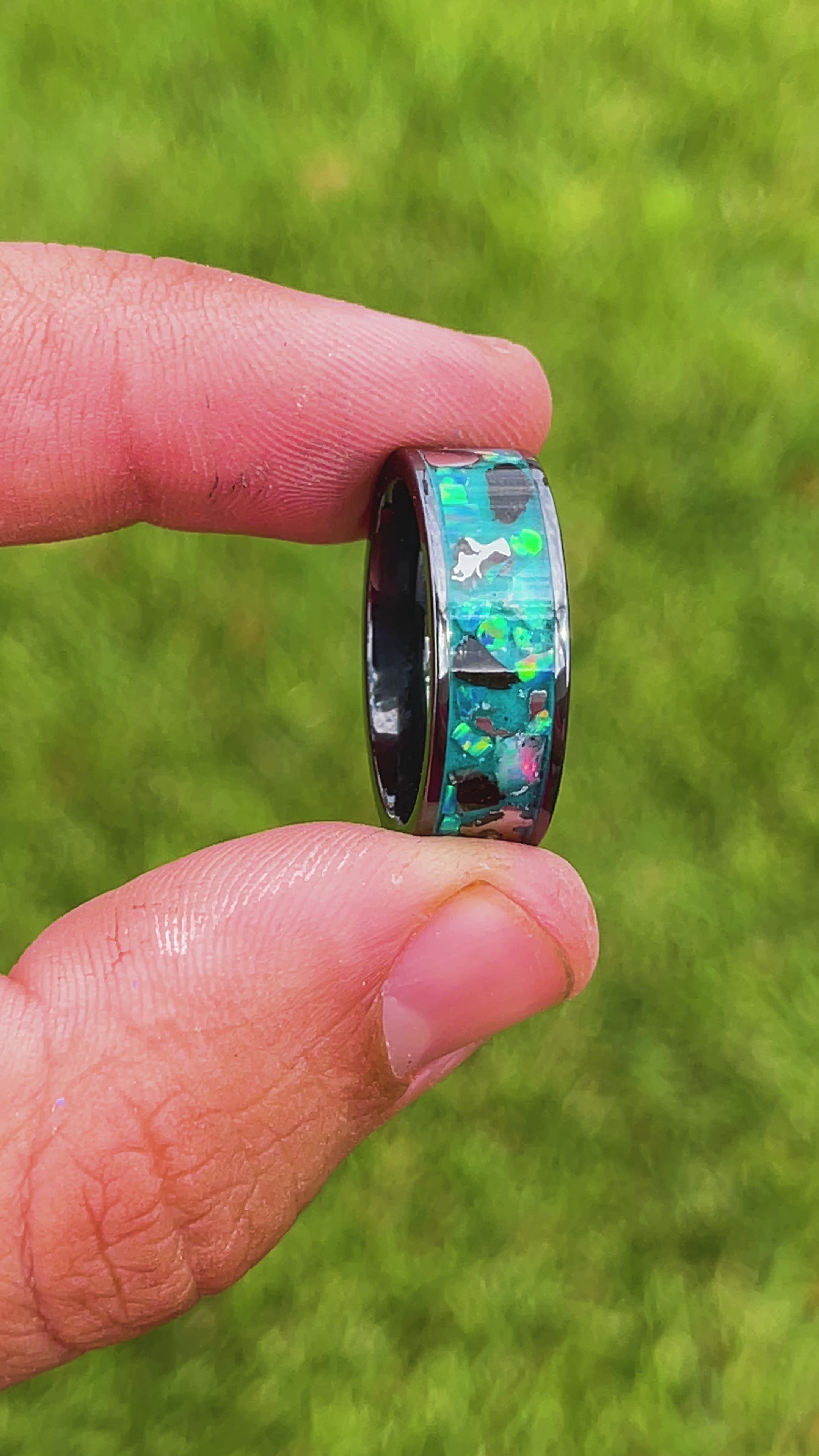 360 degree product view of the Epic Megalodon Glow ring showing large Megalodon tooth pieces and Campo del Cielo meteorite chunks shifting through oasis opal inlay transitioning to blue glow in the dark on wide channel tungsten band