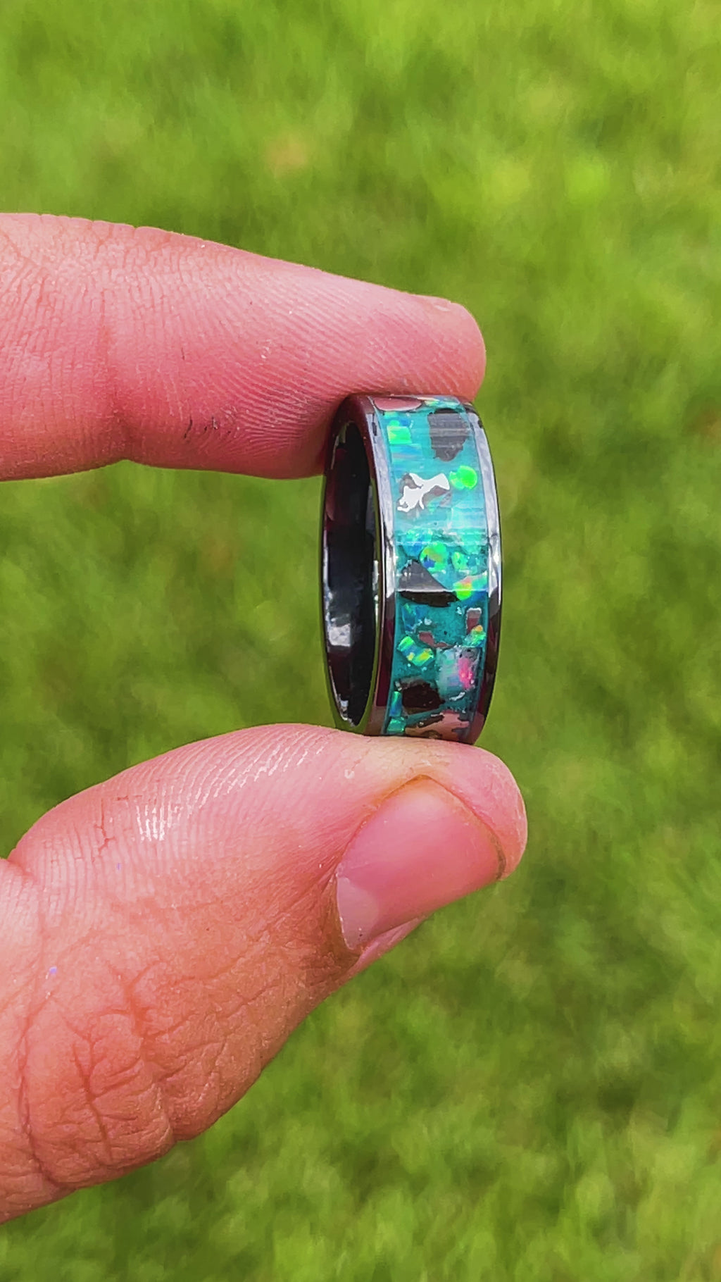 360 degree product view of the Epic Megalodon Glow ring showing large Megalodon tooth pieces and Campo del Cielo meteorite chunks shifting through oasis opal inlay transitioning to blue glow in the dark on wide channel tungsten band