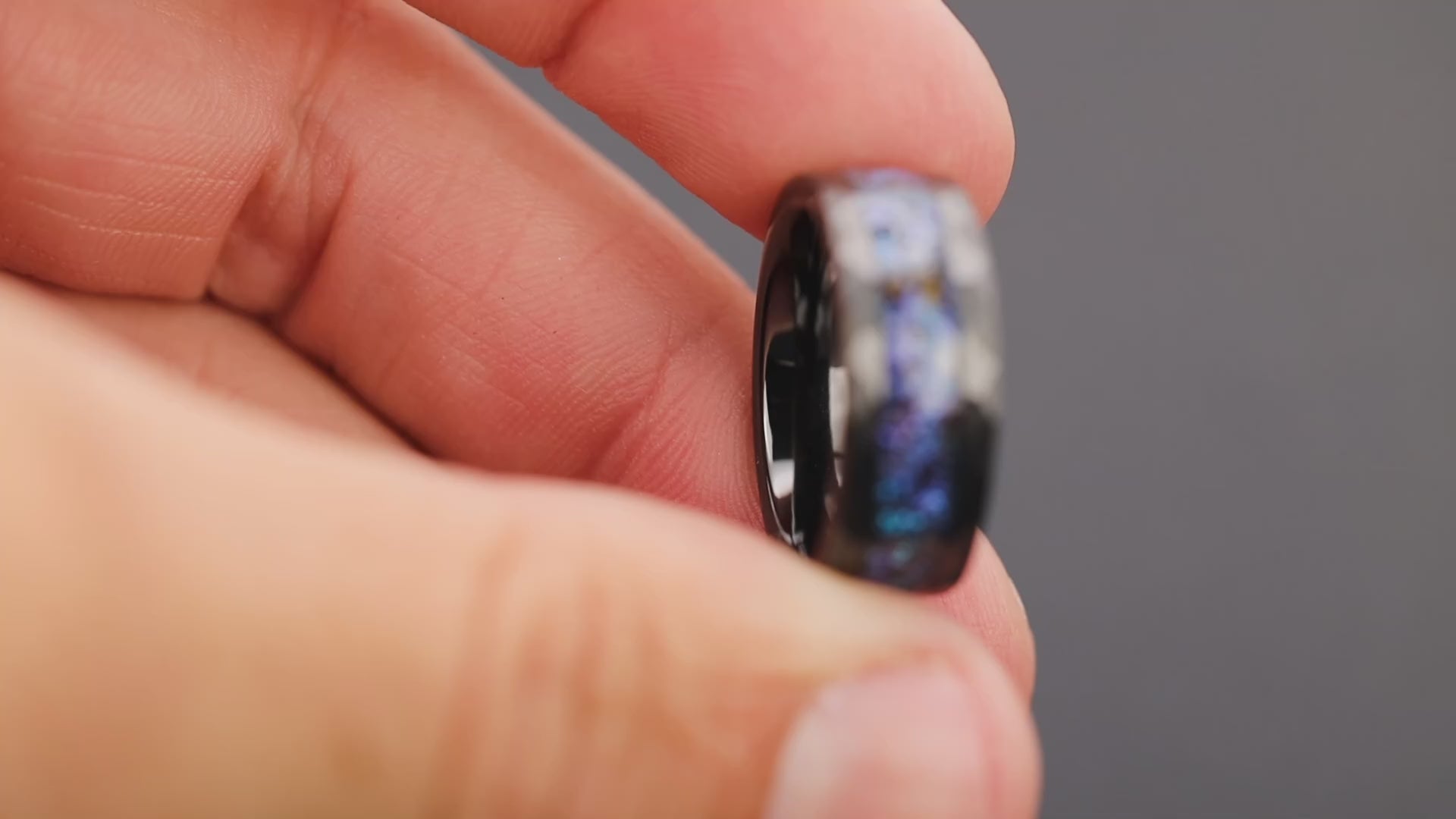 360 degree product view of the Hammered Rex Galaxy ring showing T-Rex bone and Campo del Cielo meteorite shifting through blue and purple opal galaxy inlay on hammered black ceramic band