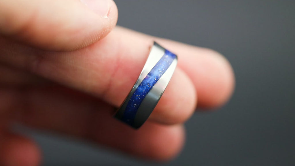 360 degree product view of the Blue Drift ring showing Campo del Cielo meteorite pieces shifting through blue resin in curved inlay channel on 8mm tungsten band