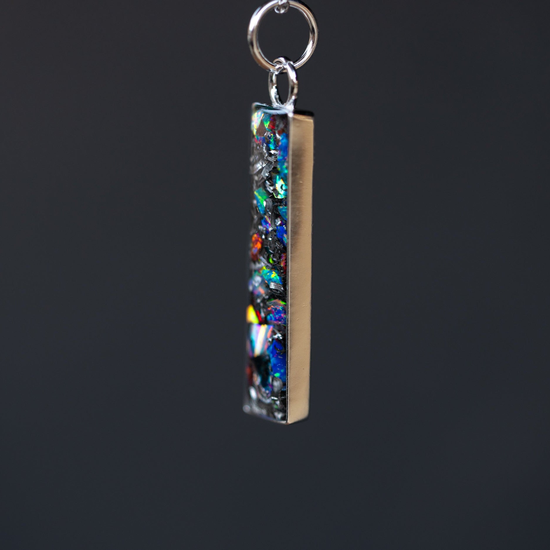 Close-up of the Prism Bar rainbow opal necklace showing Campo Del Cielo iron meteorite fragments set with red, blue, purple, green, white, and orange opals