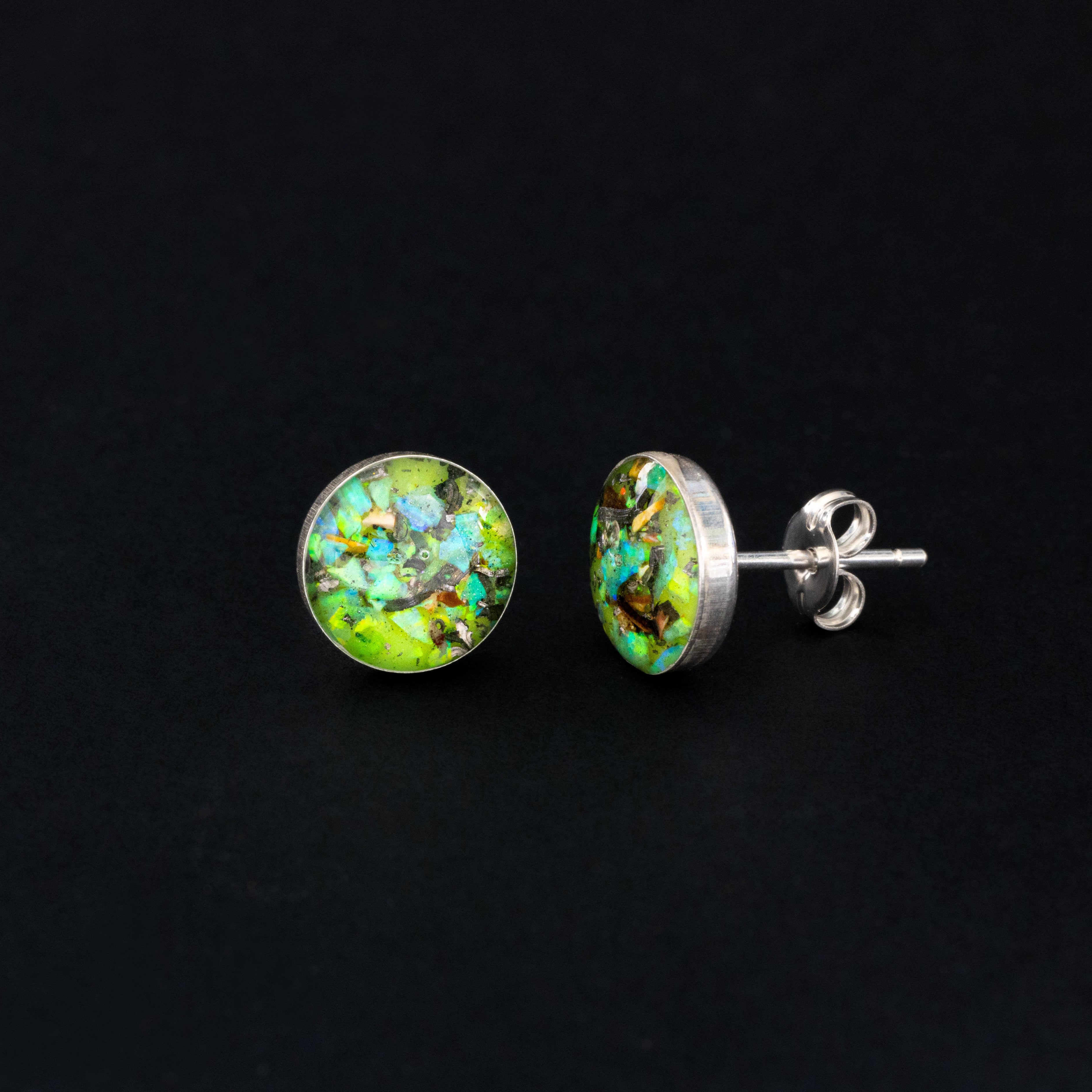 Handcrafted velociraptor fossil silver stud earrings with Campo Del Cielo meteorite, real dinosaur bone, green opal, and neon green glow in the dark pigment