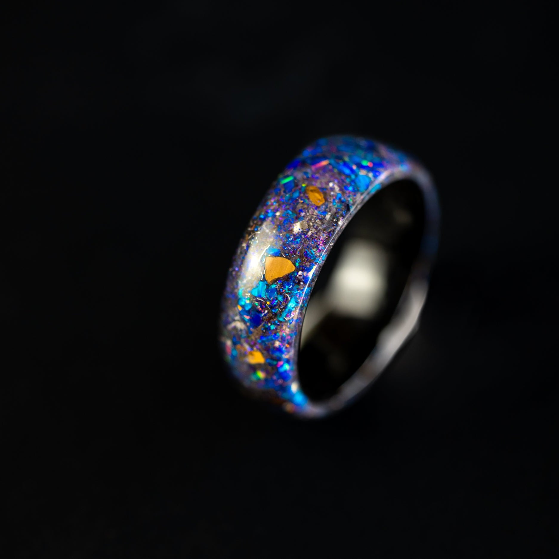 Endless black ceramic ring with authentic Velociraptor bone, meteorite, and blue and purple galaxy glitter inlay.