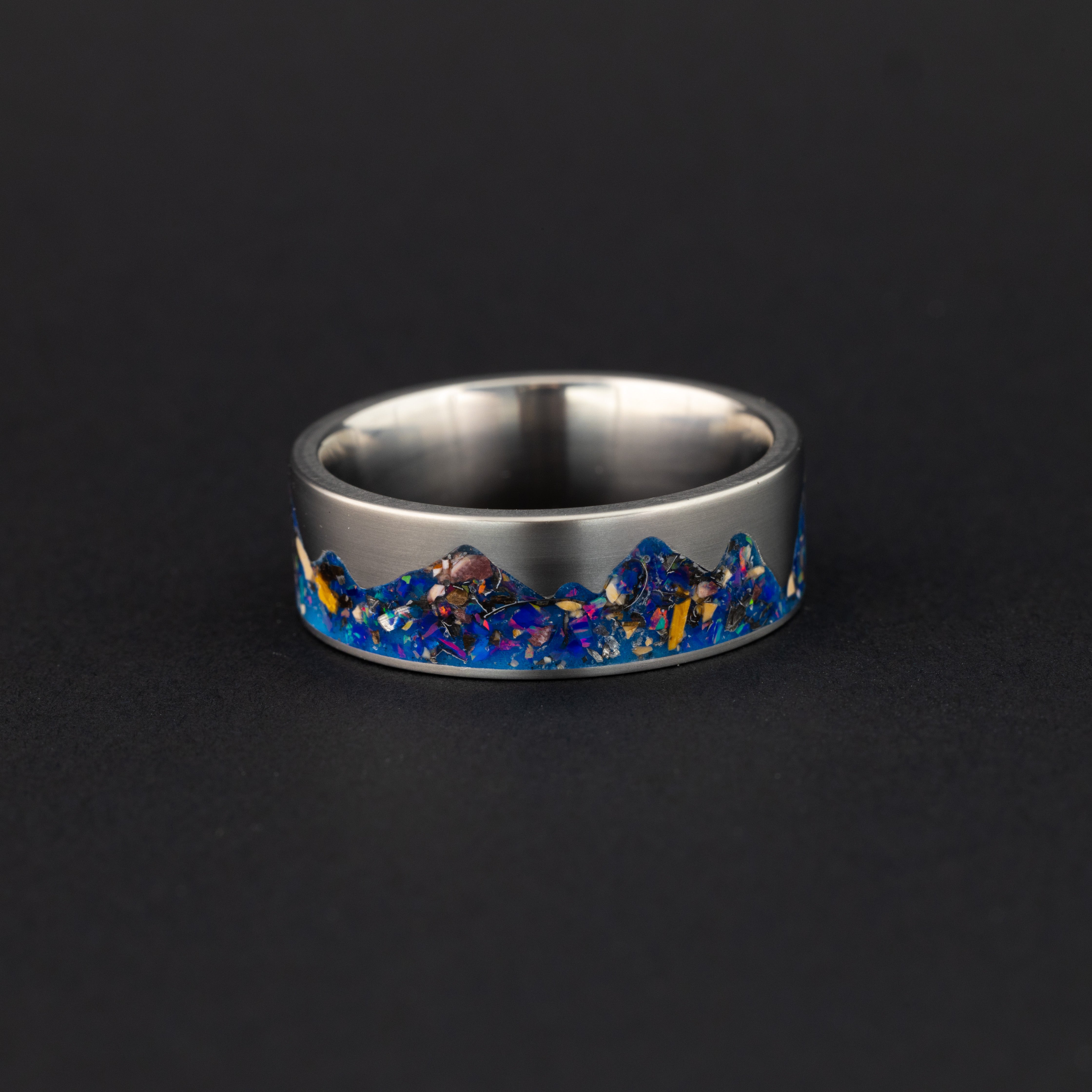 Side profile of the handcrafted titanium Raptor Ridgeline ring with midnight opal inlay made in a California studio.