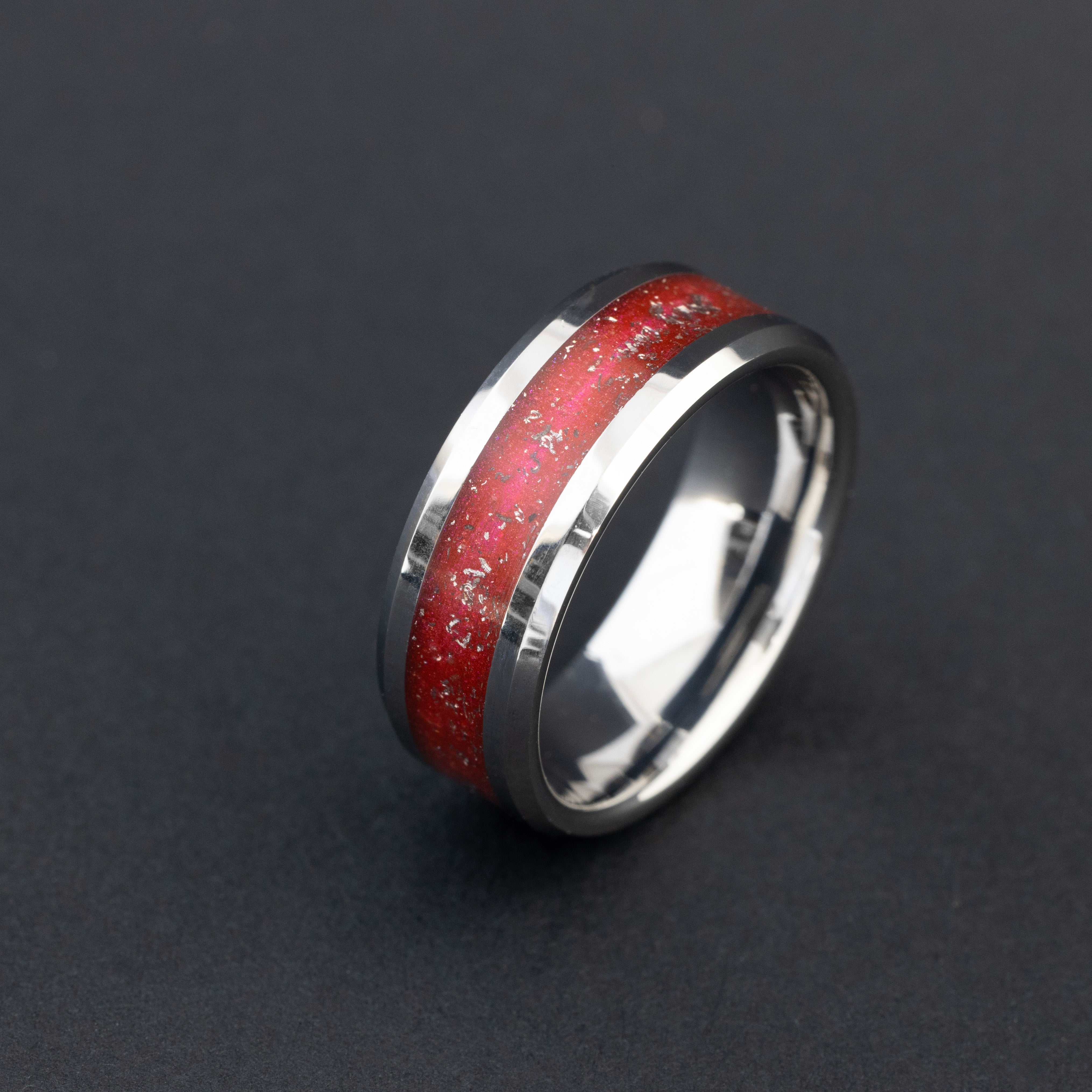 Close up of Campo del Cielo meteorite shavings in a vibrant red 8mm tungsten ring.