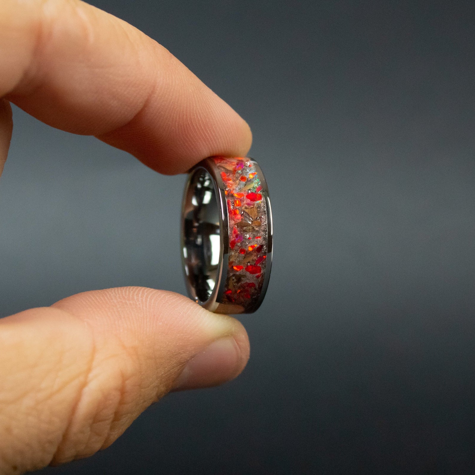Red Rex Glow ring glowing red in total darkness showing T-Rex bone and meteorite suspended in electric red glow in the dark