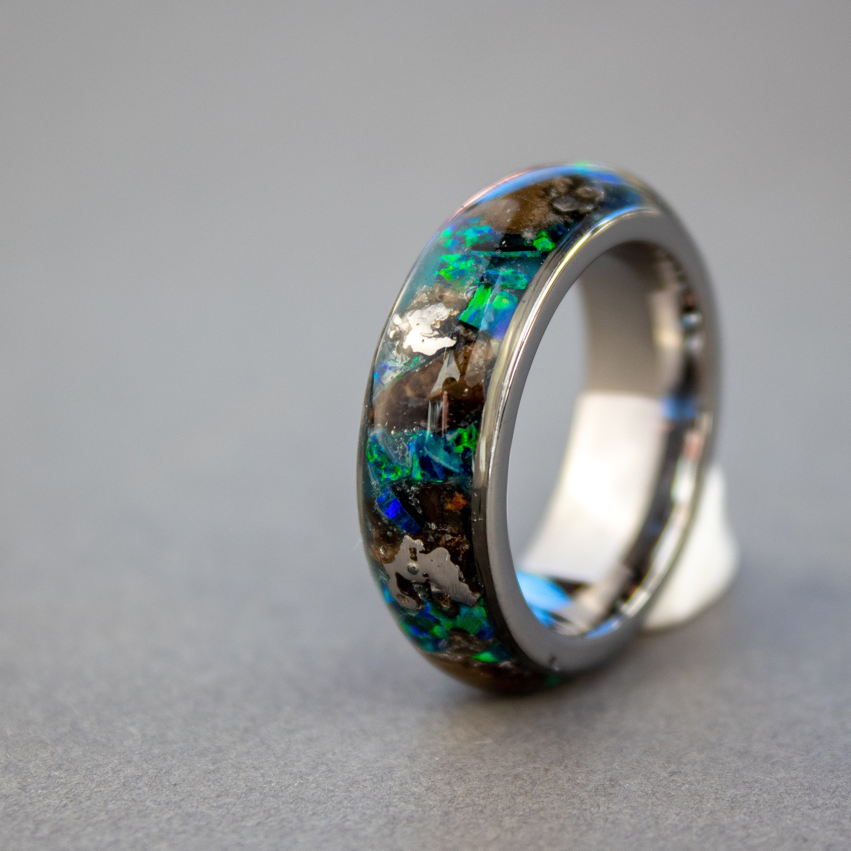 8mm wide channel tungsten ring with large pieces of authentic T-Rex bone and Campo del Cielo meteorite in blue and green opal inlay glowing blue in the dark