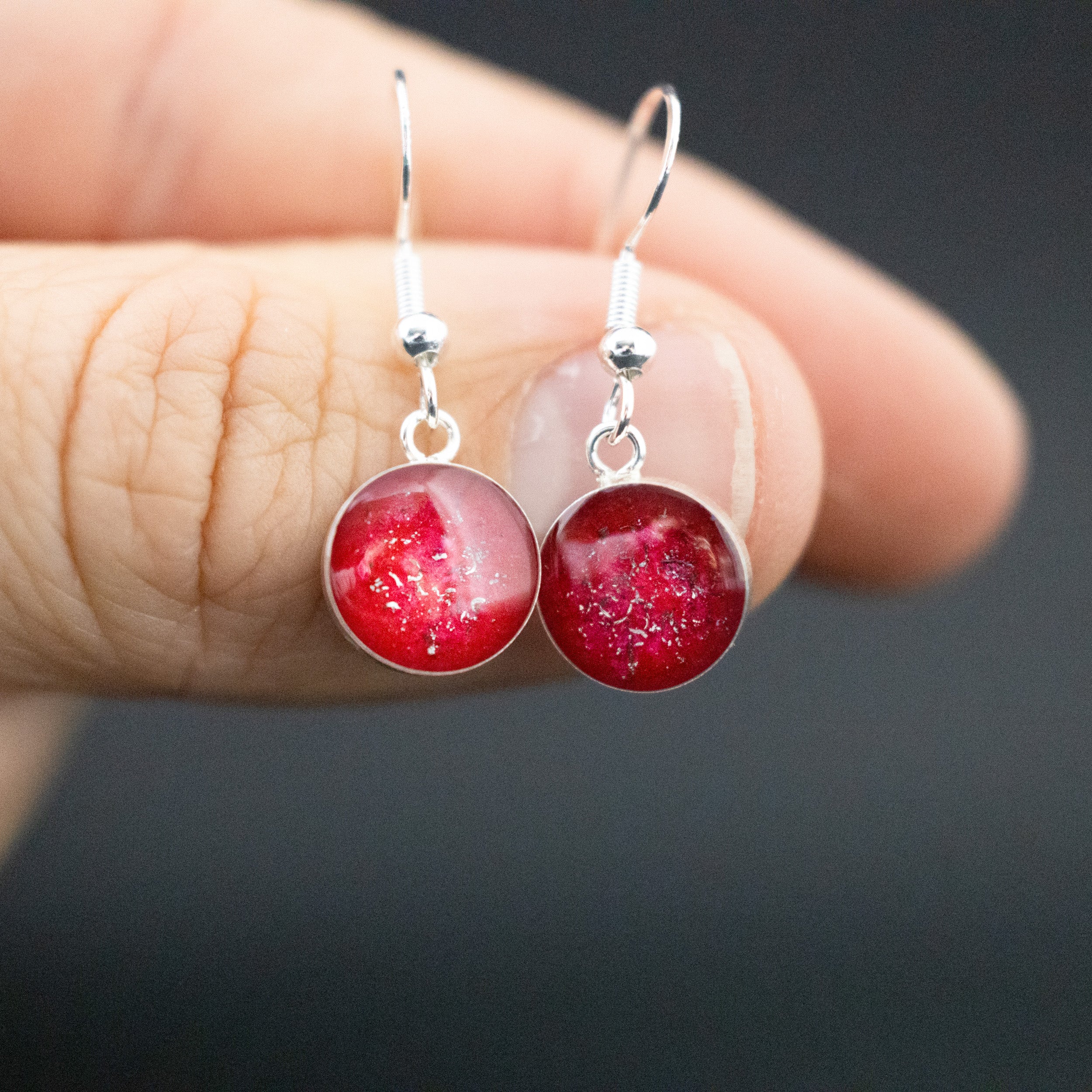 Close-up of the Ruby Dangle red drop earrings showing Campo Del Cielo iron meteorite set in deep ruby red resin with sterling silver French hook ear wires