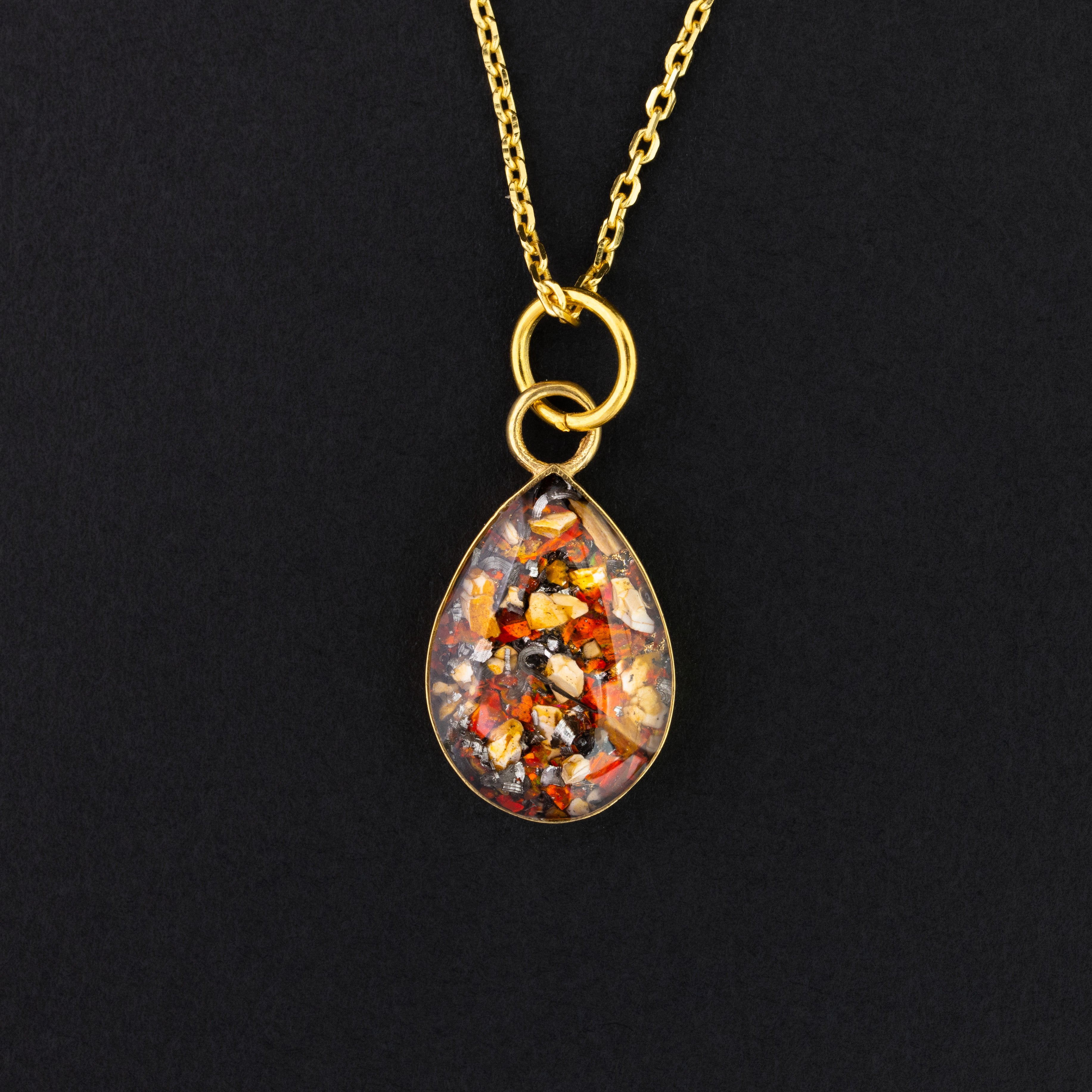 Ruby Raptor Drop teardrop pendant necklace in gold-plated sterling silver with Campo Del Cielo meteorite, red opal, and velociraptor fossil inlay