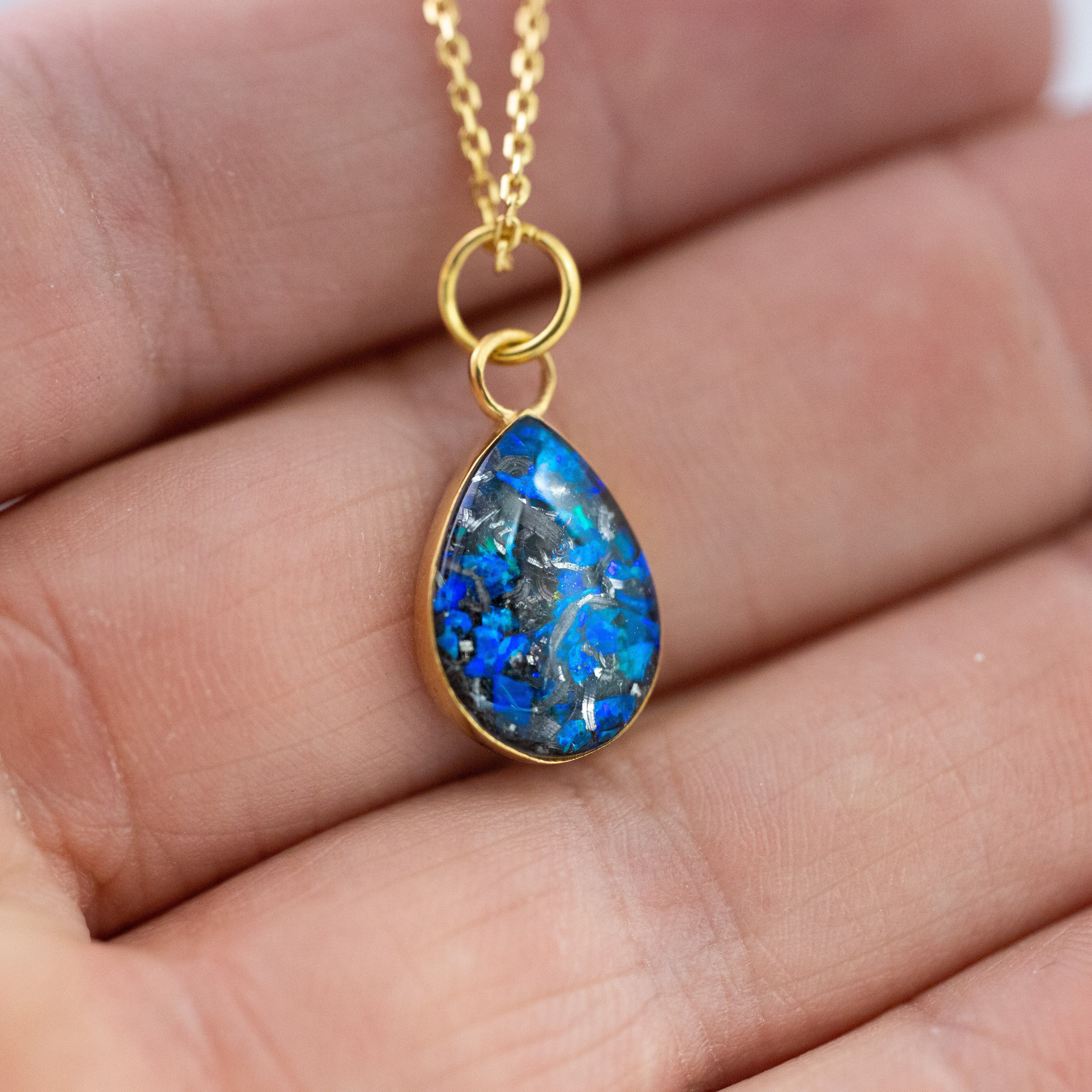 Close-up of the Sapphire Comet pendant showing authentic Campo Del Cielo meteorite fragments set with vivid blue opal