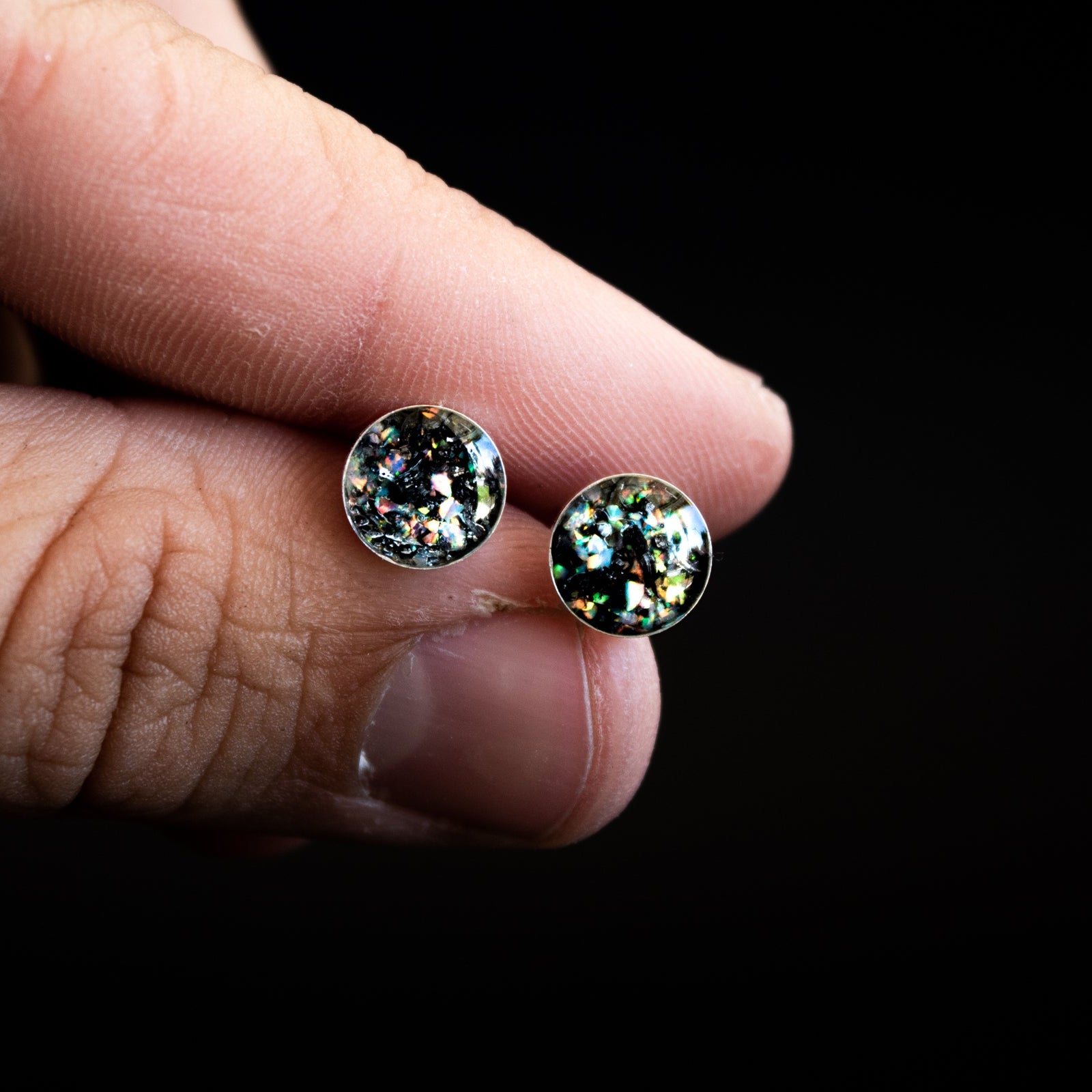 Close-up of the Shimmer Meteorite Studs showing Campo Del Cielo iron meteorite set with iridescent white opal flashing pink, blue, and green