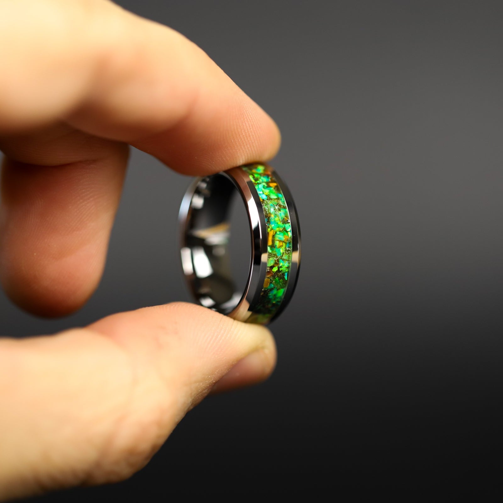 Toxic Raptor Tungsten ring glowing green in total darkness showing Velociraptor bone and meteorite suspended in electric green glow in the dark inlay