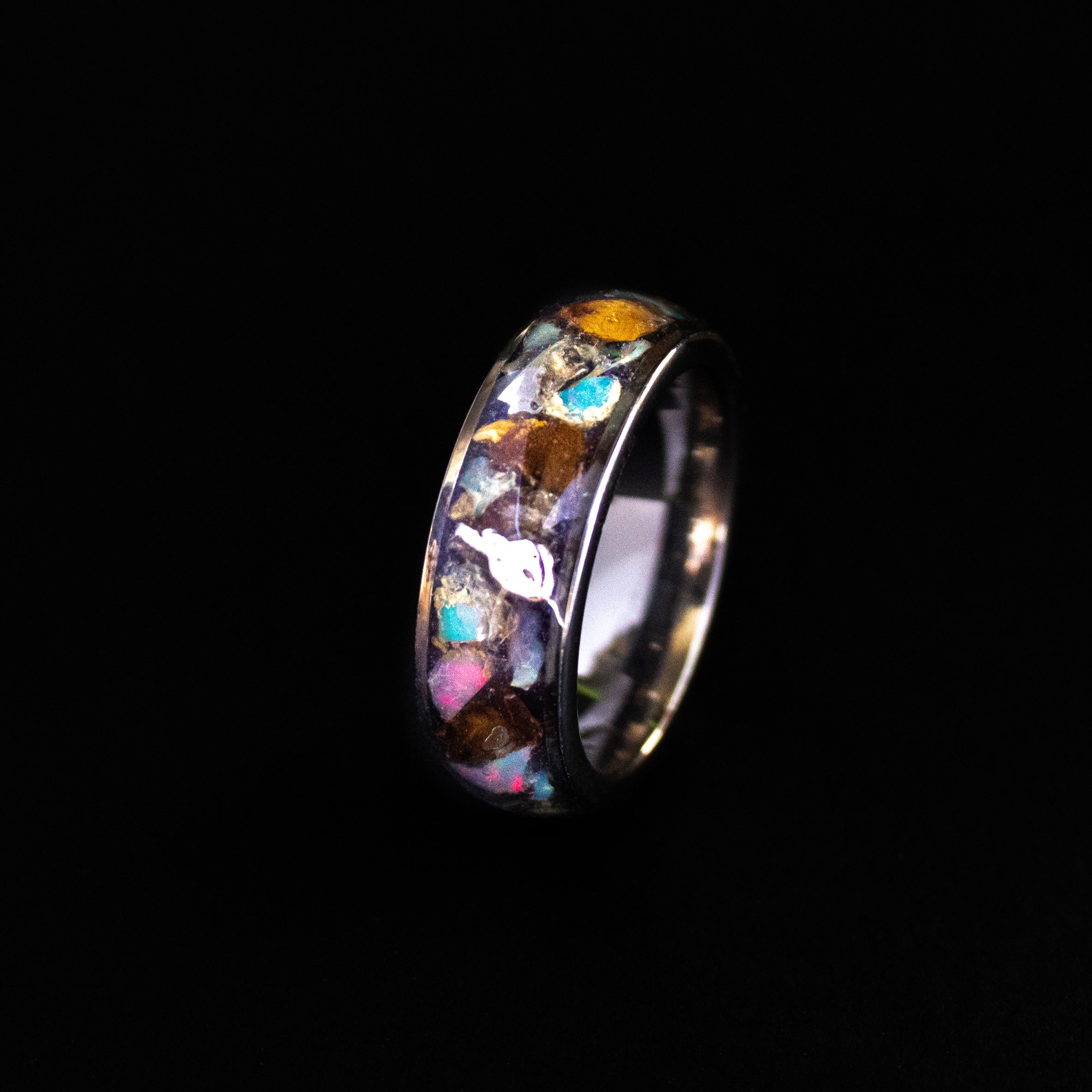 Close up of large genuine T-Rex fossil pieces, Campo del Cielo meteorite chunks, and Ethiopian Opal fire play on wide channel tungsten ring