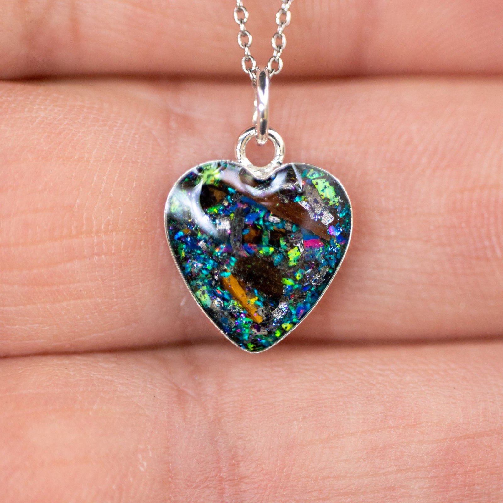 Handcrafted tyrannosaurus rex and velociraptor fossil heart pendant necklace in sterling silver with Campo Del Cielo meteorite and real dinosaur bone inlay