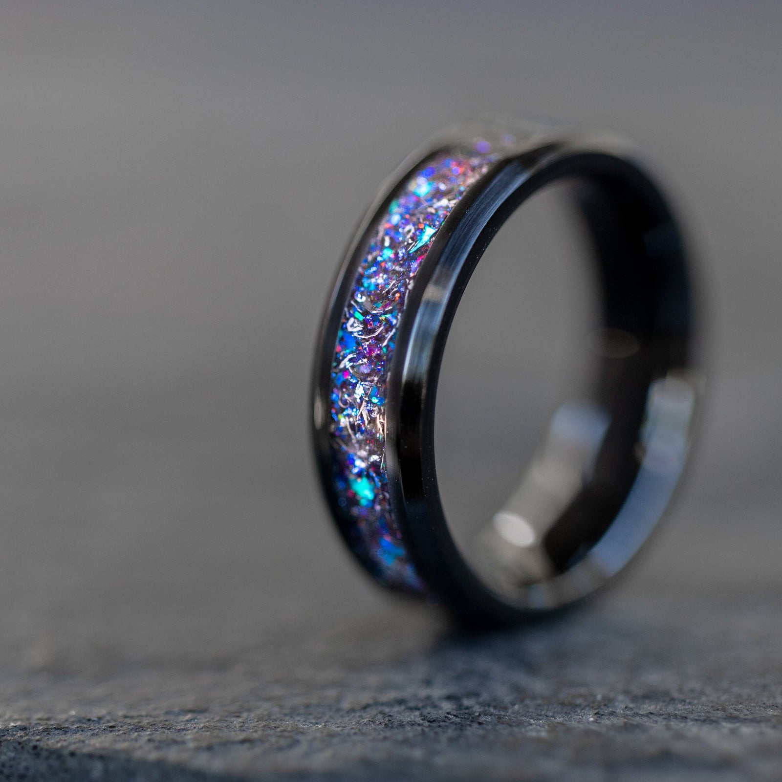 Beveled black ceramic ring with authentic Campo del Cielo meteorite shavings and blue and purple opal galaxy inlay