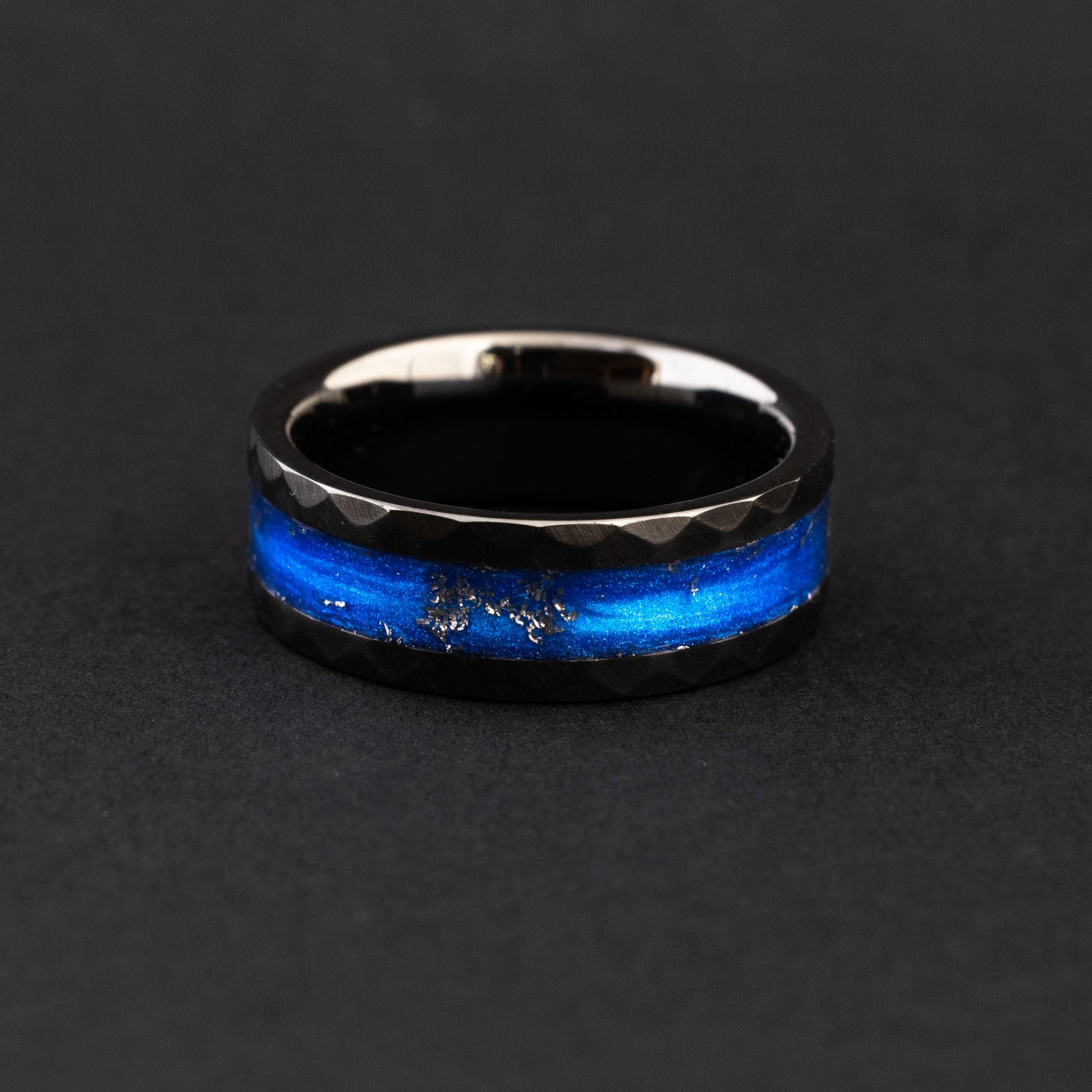 Handcrafted hammered black ceramic wedding band featuring celestial meteorite fragments and blue inlay.