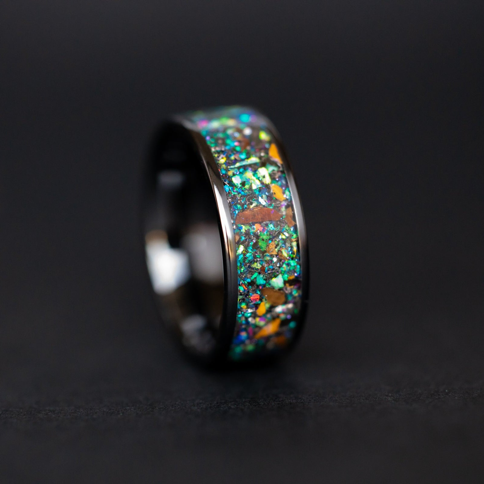 Handcrafted 8mm wide channel black ceramic mens wedding band with authentic T-Rex and Velociraptor bone and Campo del Cielo meteorite in blue green galaxy inlay made in California