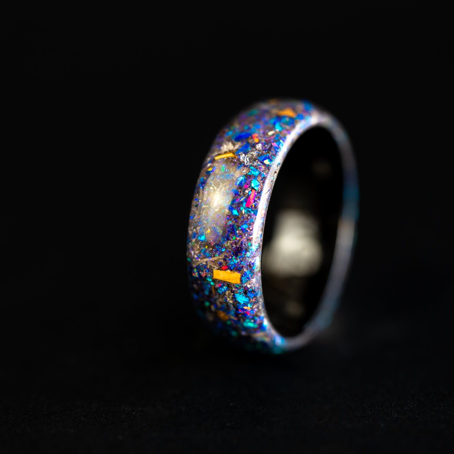 Handcrafted endless black ceramic wedding band featuring prehistoric raptor bone and celestial galaxy shimmer.